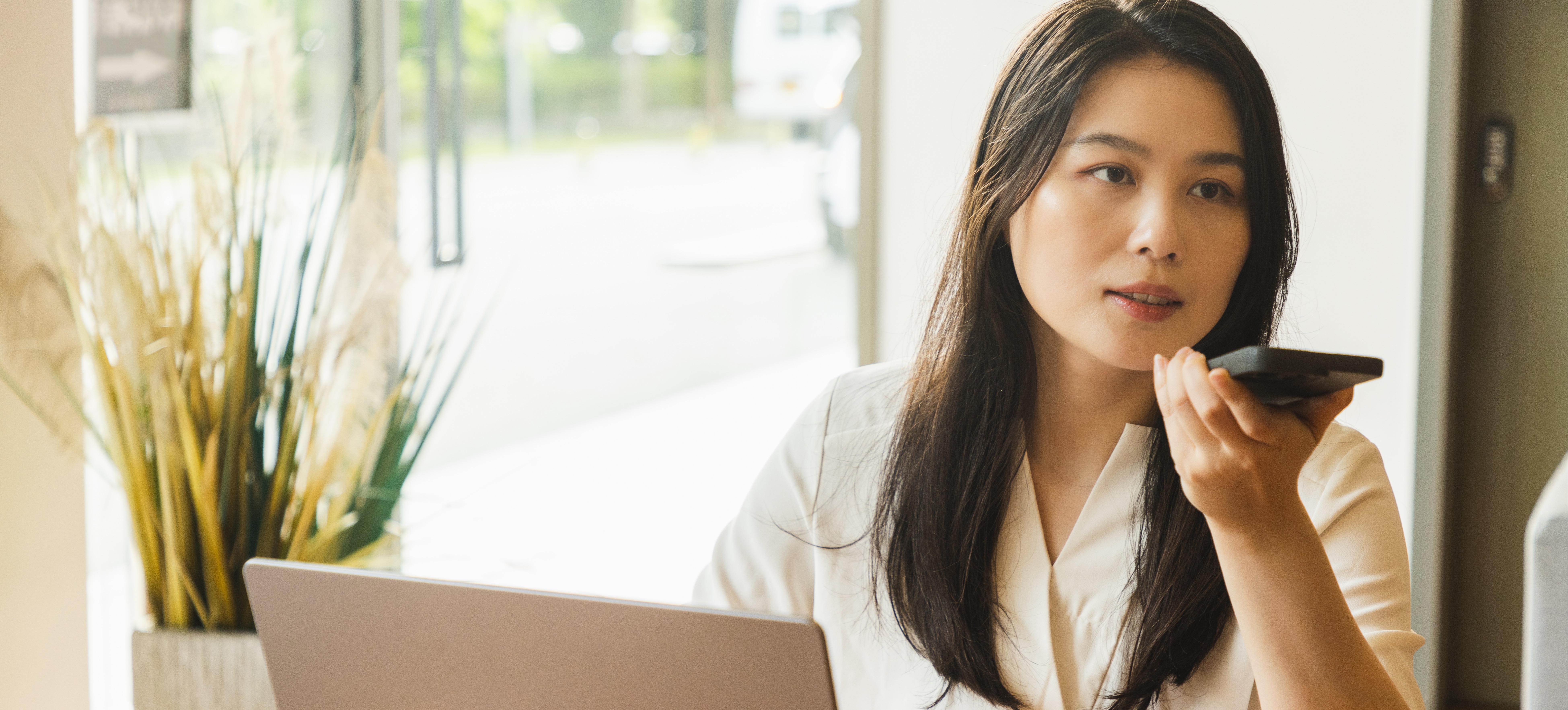 [Featured Image] A cybersecurity professional sits at a workspace with a laptop and phone, utilizing AWS security tools to help defend their company’s cloud data.
