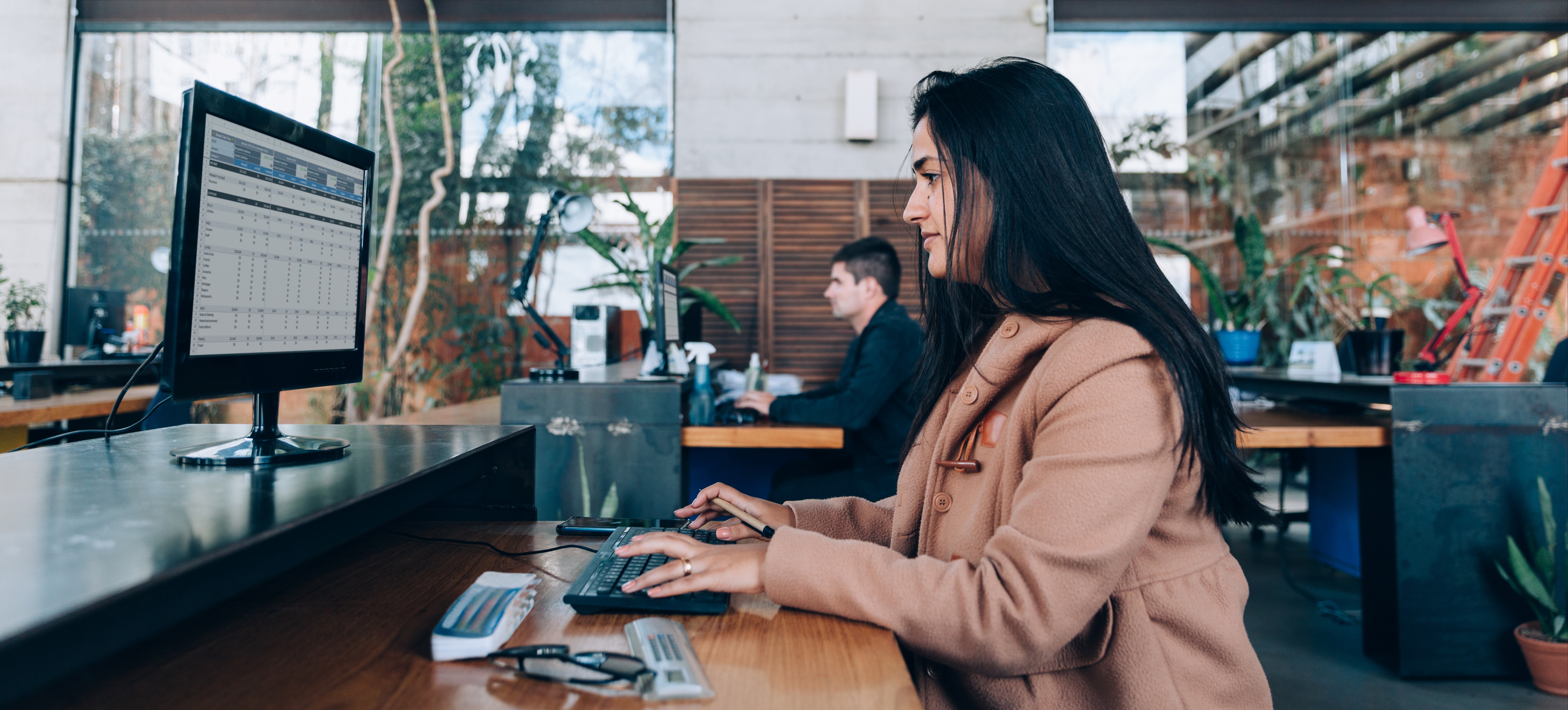 [Featured Image] A professional working in an office environment, using Power BI tools on a computer to analyze and visualize data.
