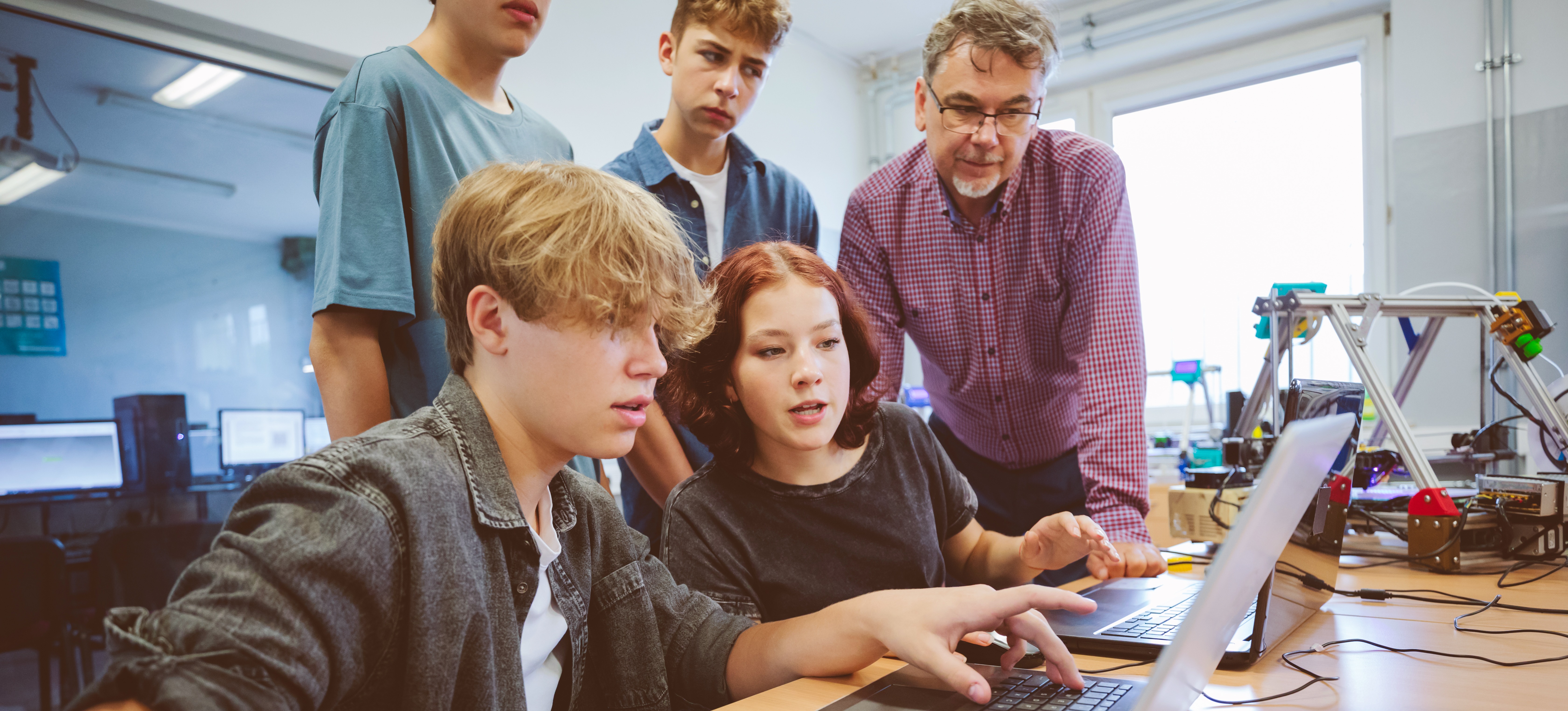[Featured Image] Students in an a level class are working on a group project guided by the instructor.