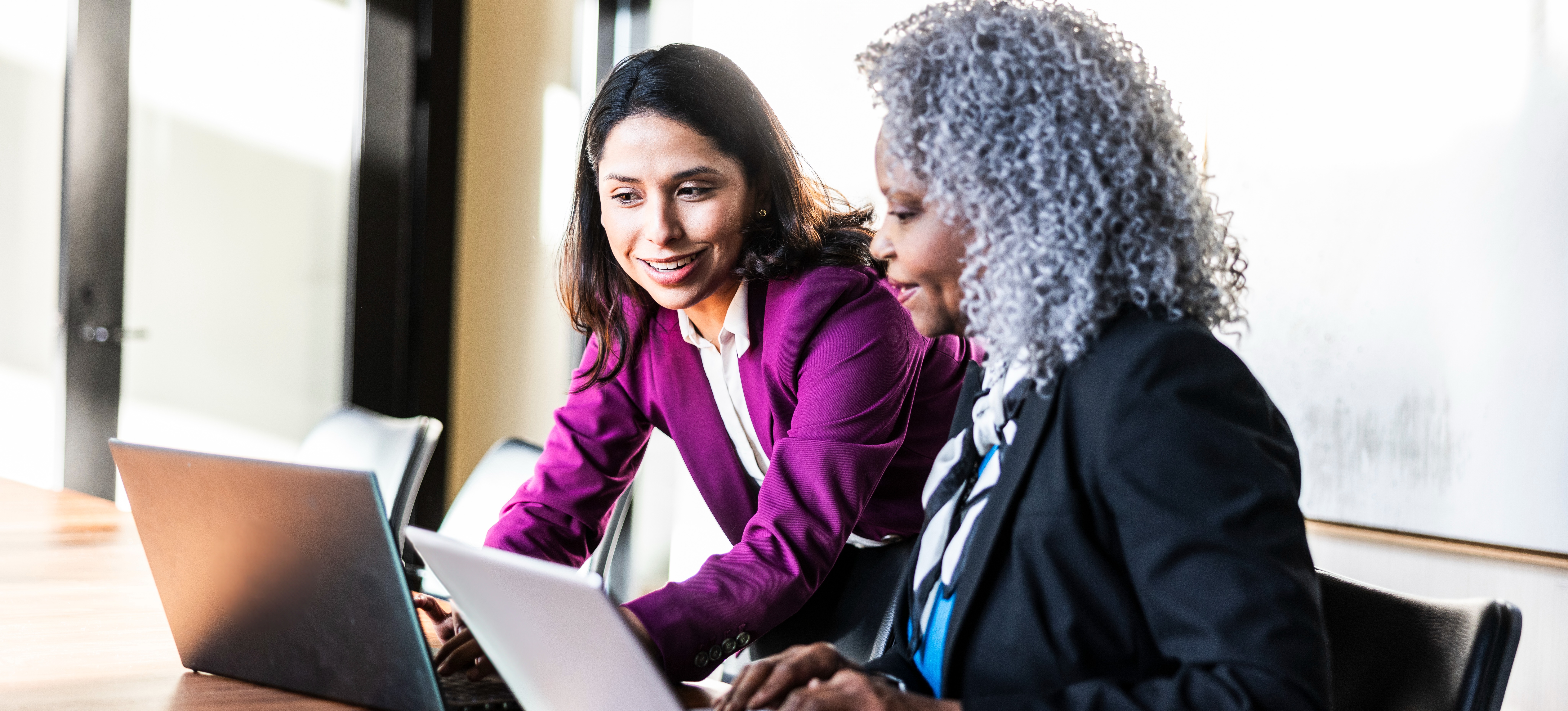 [Feature Image] Two analysts discuss the sample size of a project they are working on prior to performing analysis. 
