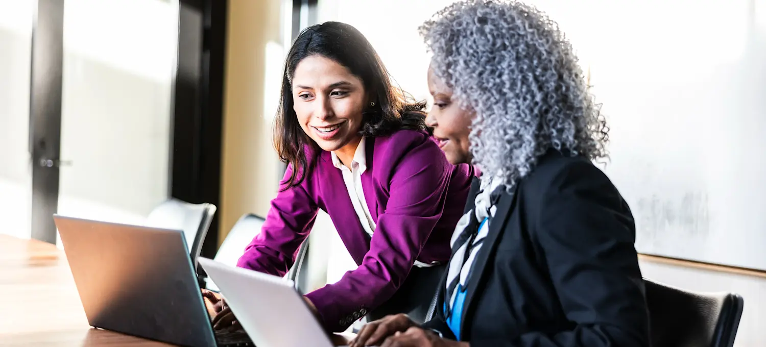 [Feature Image] Two analysts discuss the sample size of a project they are working on prior to performing analysis. 
