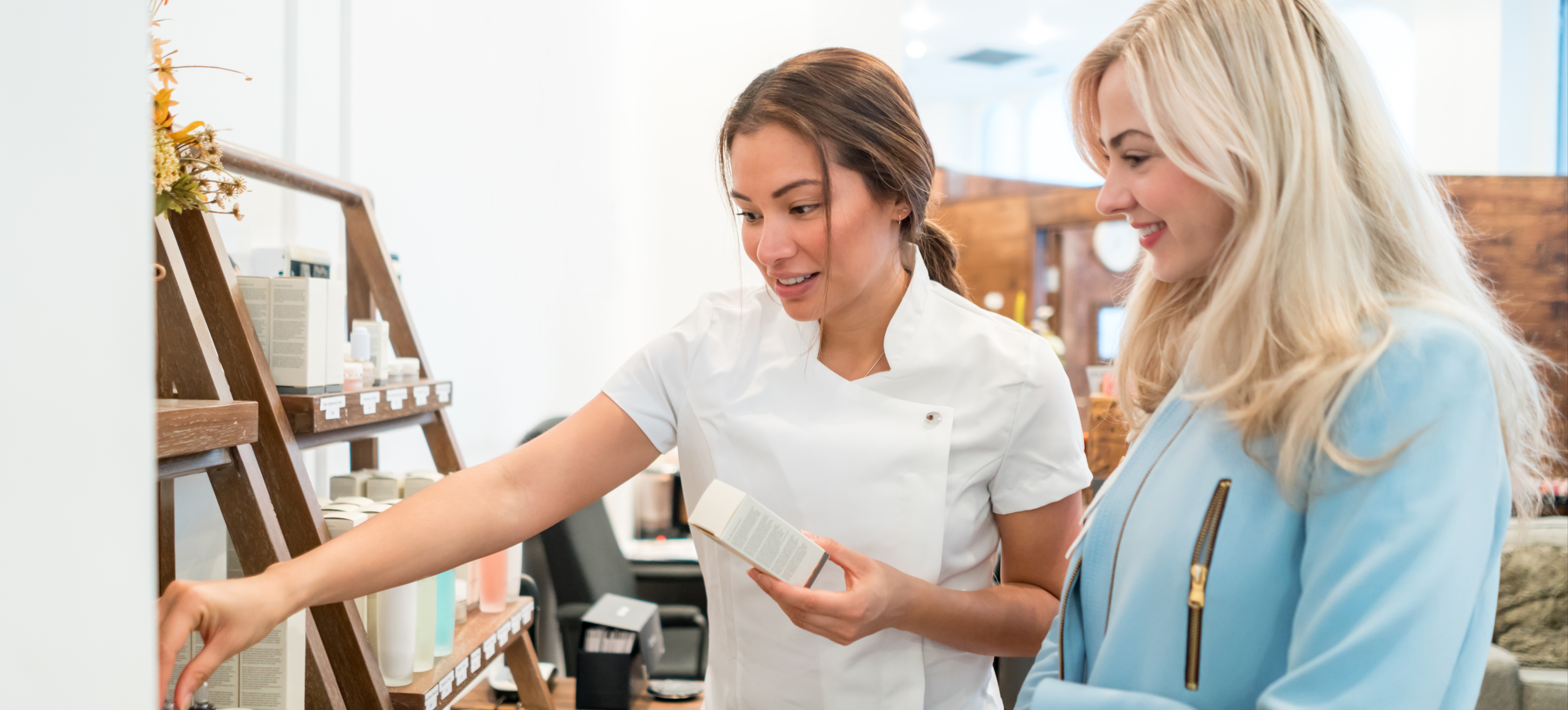 [Featured Image] A store owner shows products to a potential customer as she practices her sales techniques.
