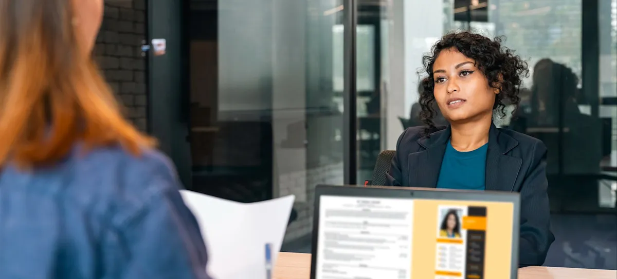 [Featured Image] A recruiter conducting an interview in a professional setting, reviewing a candidate's Linux resume displayed on their computer screen.
