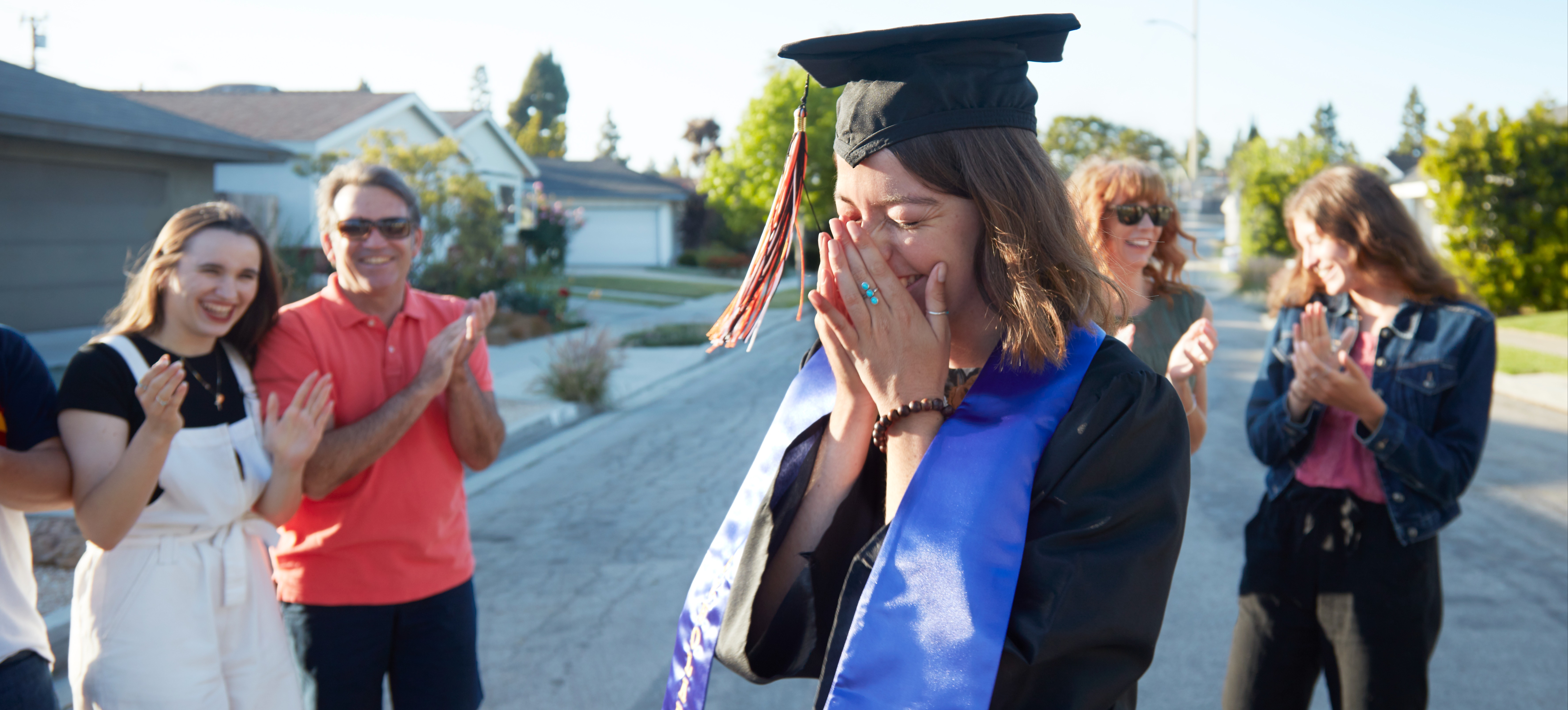 [Feature image] A young woman is celebrated by family members after finishing a baccalaureate program.
