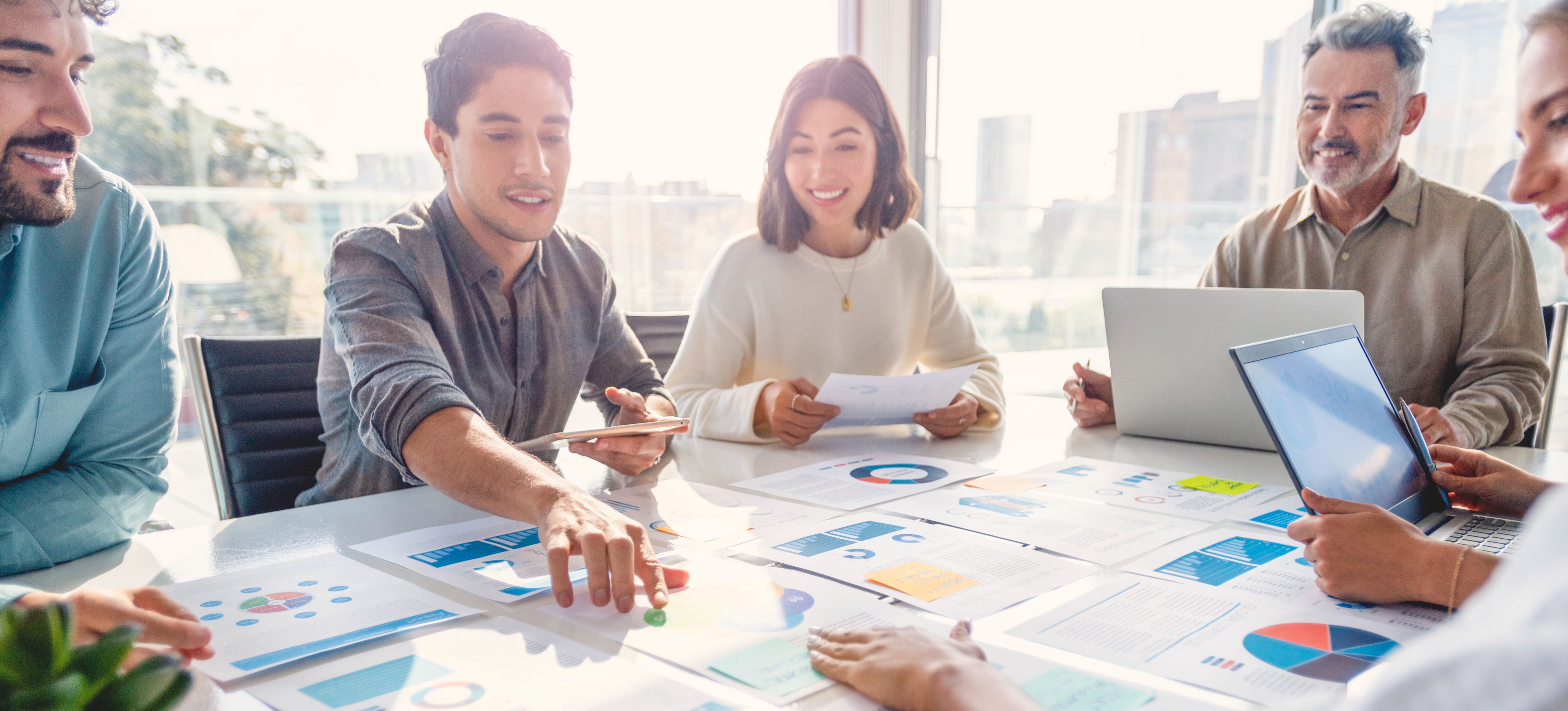 [Featured Image] A man working for a management analyst salary presents the data he’s gathered to help the company lower costs and increase revenue. 
