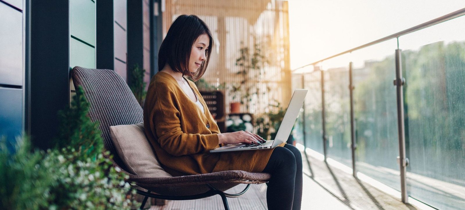 [Featured Image] A person is engaging in virtual learning as they are outside, sitting on a chair using their laptop.