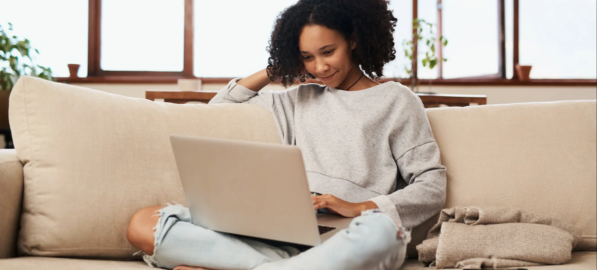 [Featured image] An entrepreneur works from home on their couch and uses Google Keyword Planner on their laptop.