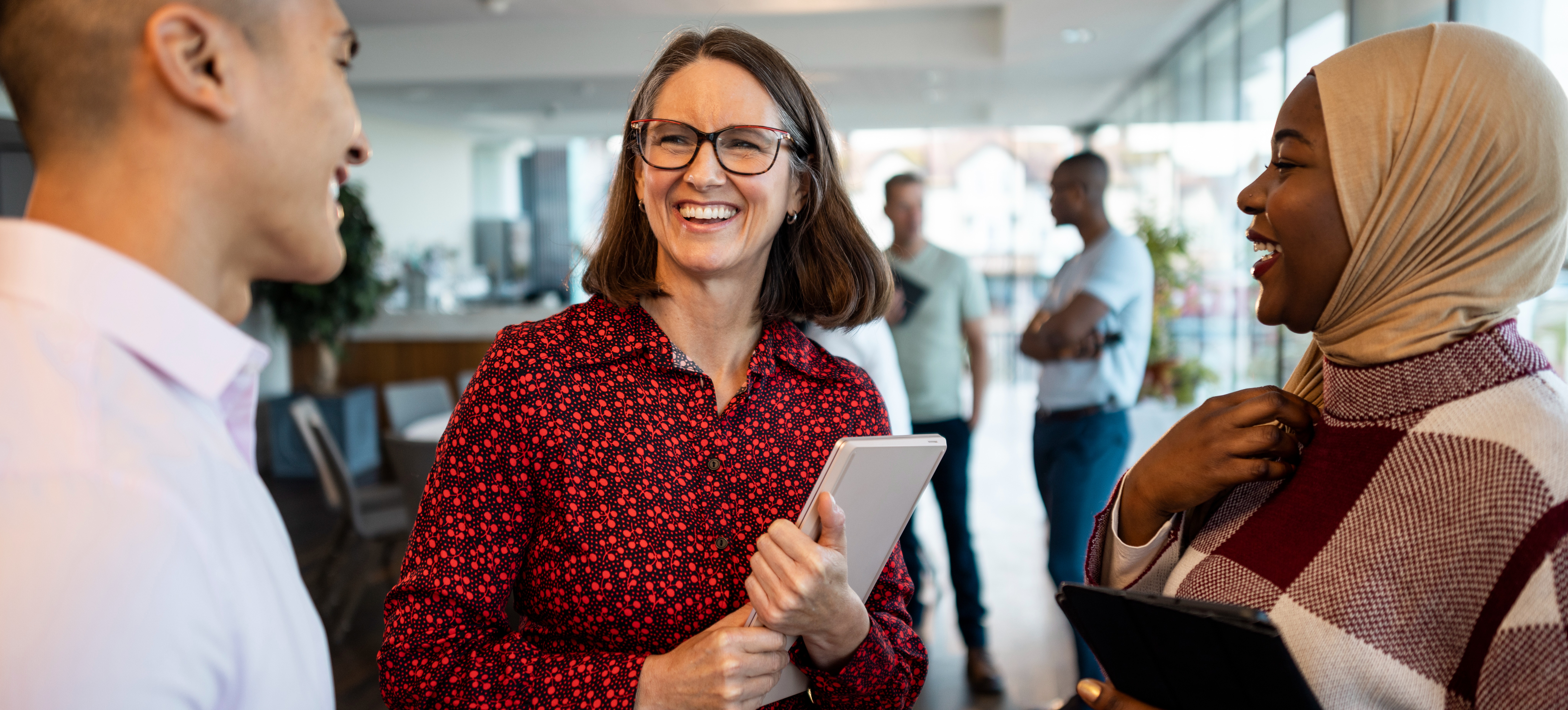 [Featured Image] A group of data scientists holding tablets meet to discuss which Power BI alternatives they may use on a new project. 
