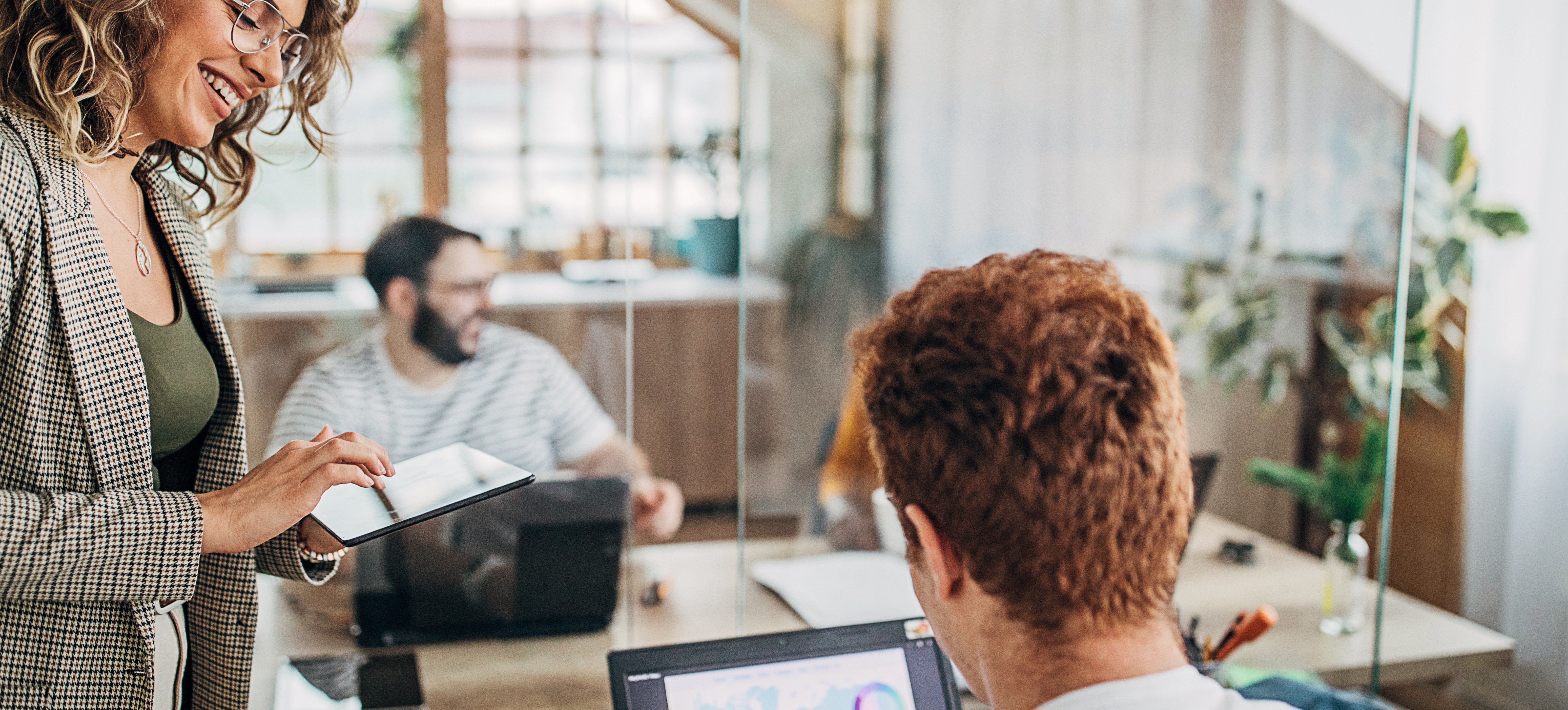 [Featured Image]: Professionals in a work environment talking about CIPP certification while reviewing data on a laptop.
