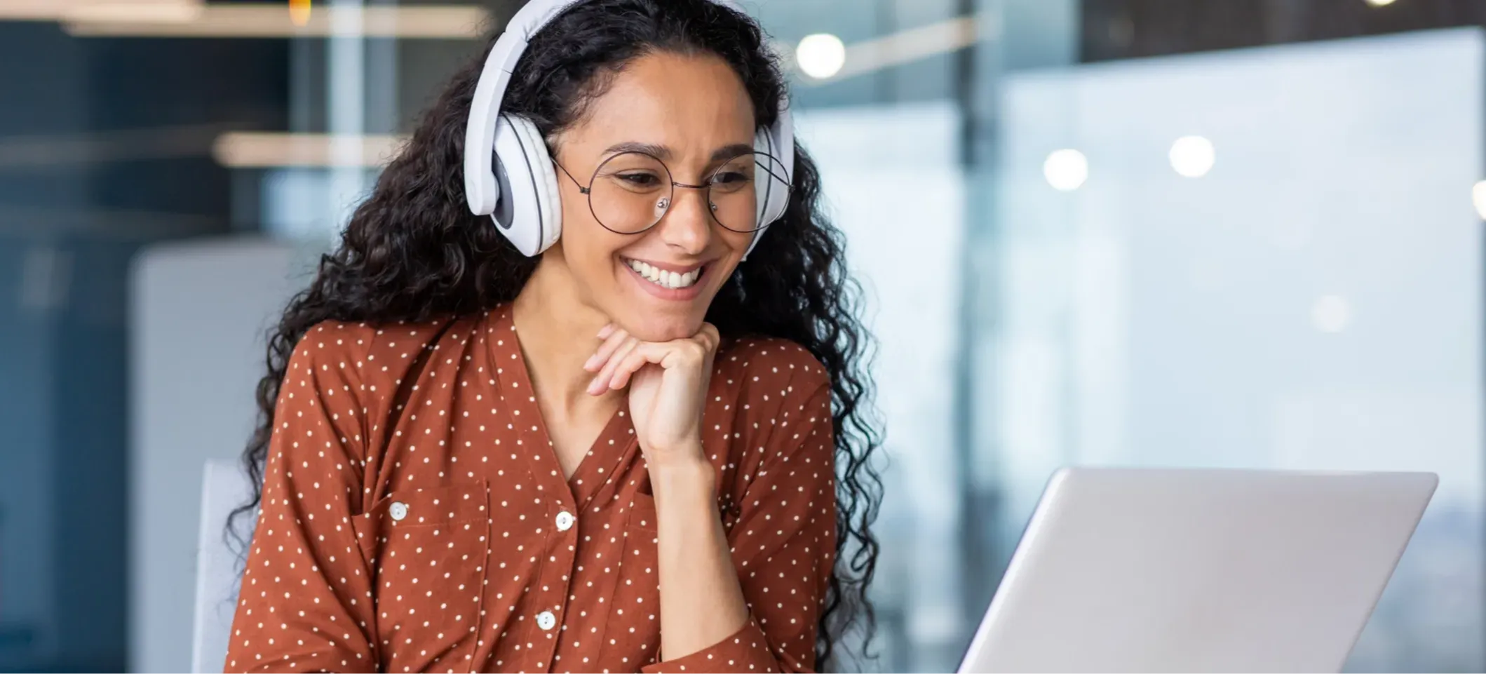 [Featured Image] A smiling person with headphones on discovers how to use ChatGPT to learn a language while looking at a laptop.
