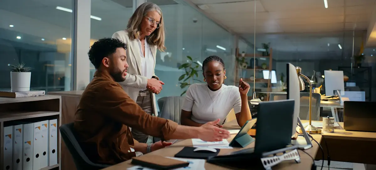 [Featured image]: Three people look at a tablet as they review the qualitative data their team collected about their customers' behavior.
