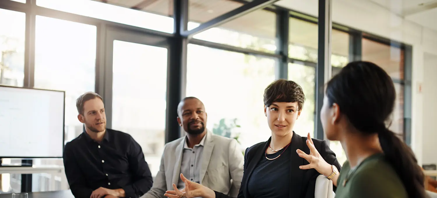 [Featured Image] Four members of the operations management team, four people are meeting around the conference table. 