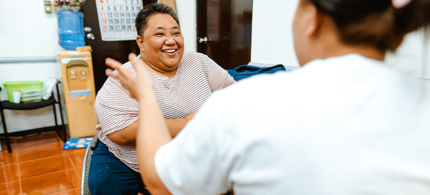 [Featured image] A smiling woman in a wheelchair is being interviewed for a data analyst position by a hiring manager.