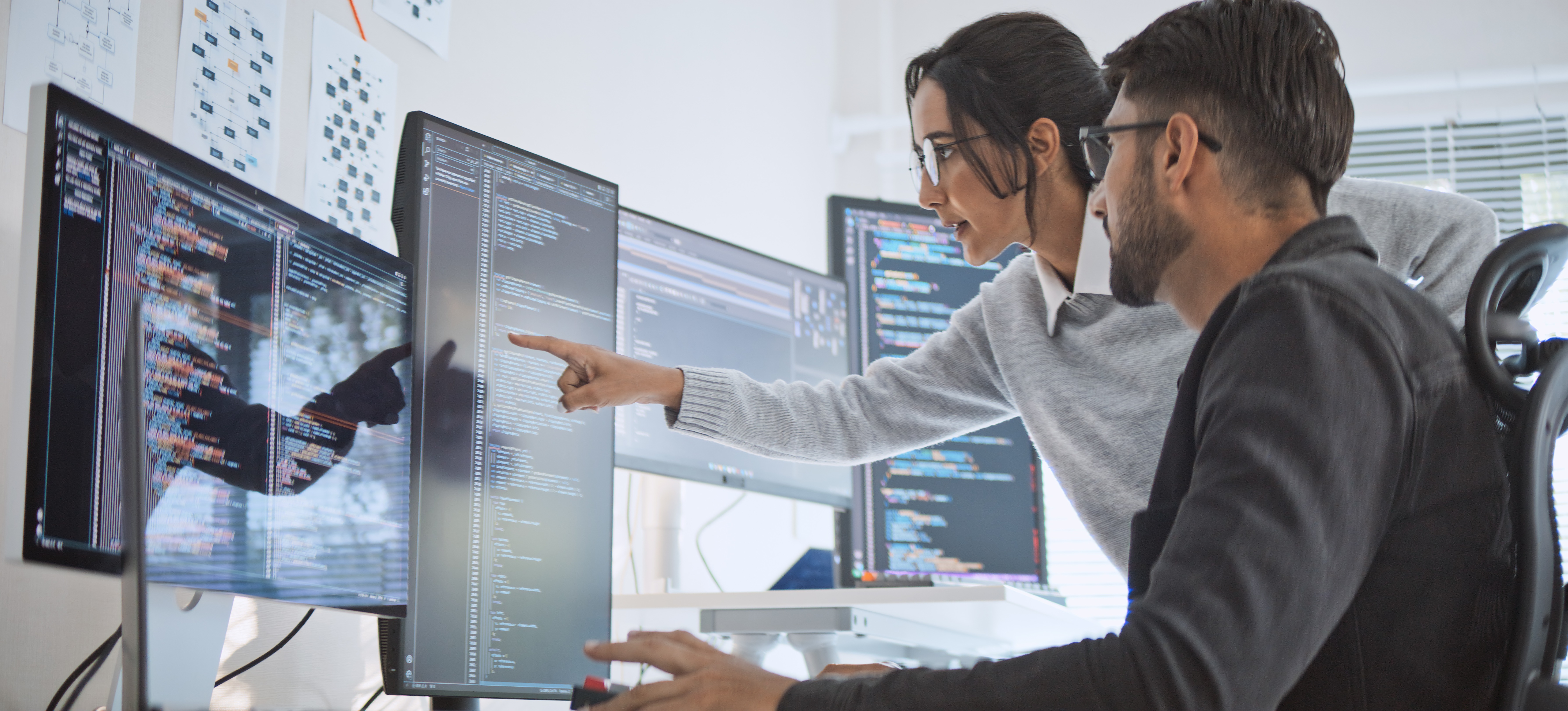 [Featured Image] Two automation testers review a software program to identify and resolve any errors to optimize its performance.