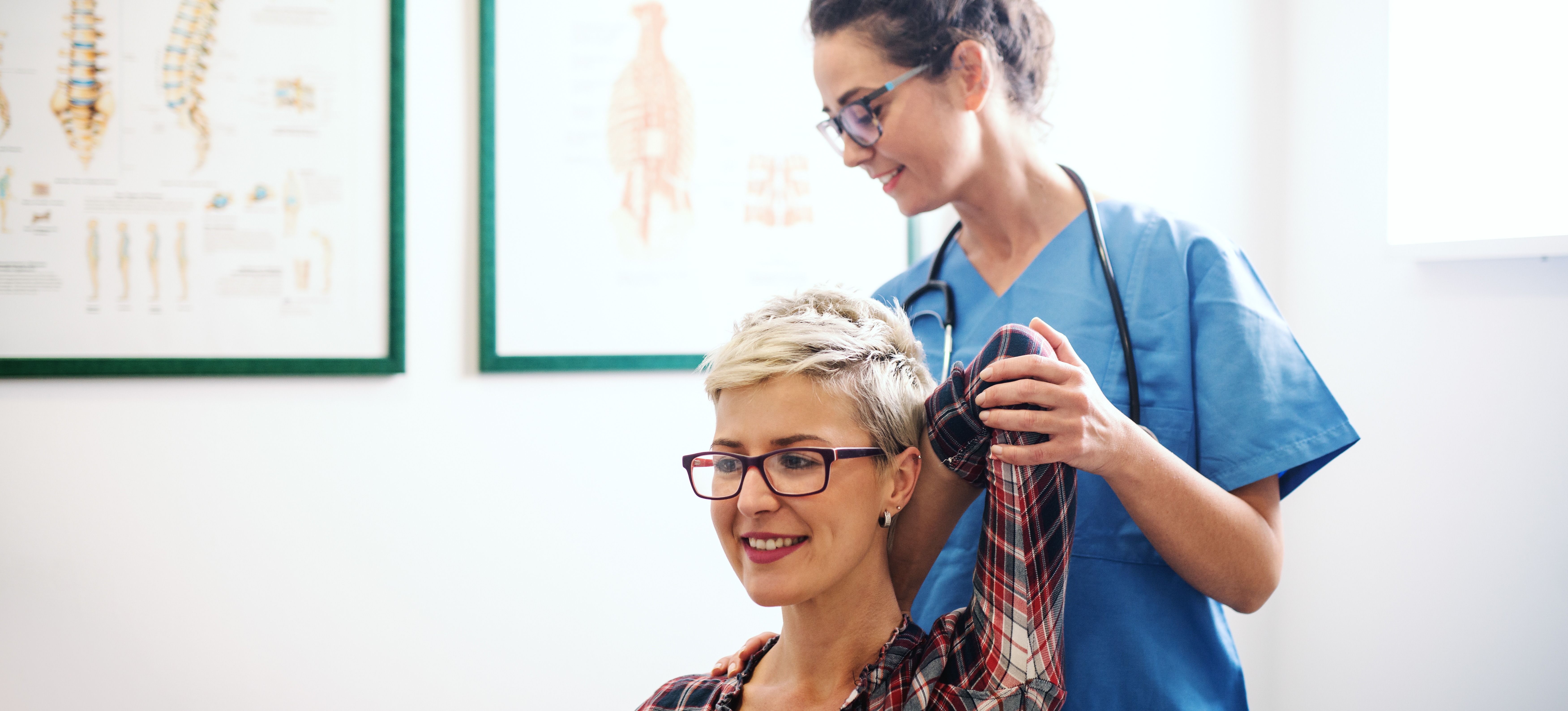 [Featured image] A chiropractor helps a patient with shoulder mobility in a clinic.
