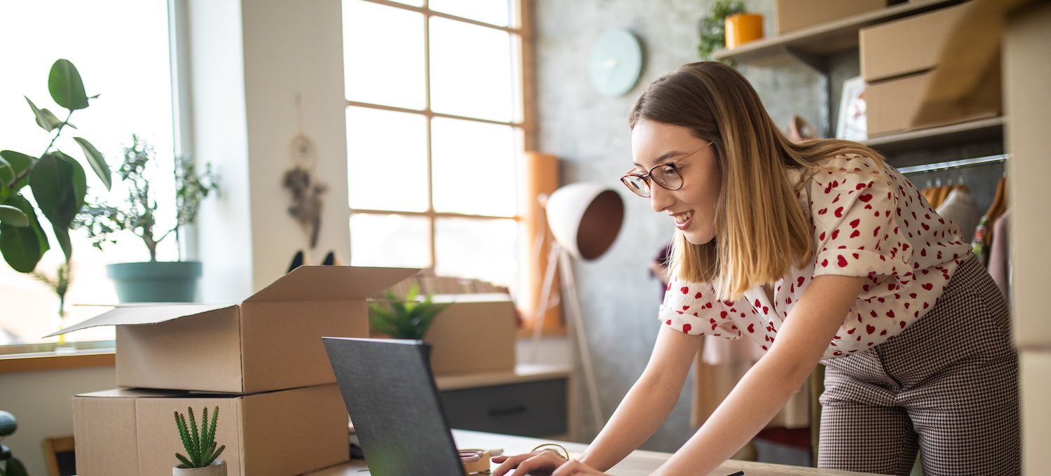 [Featured image] A sales manager stands in front of their laptop and works on an e-commerce strategy for their company.