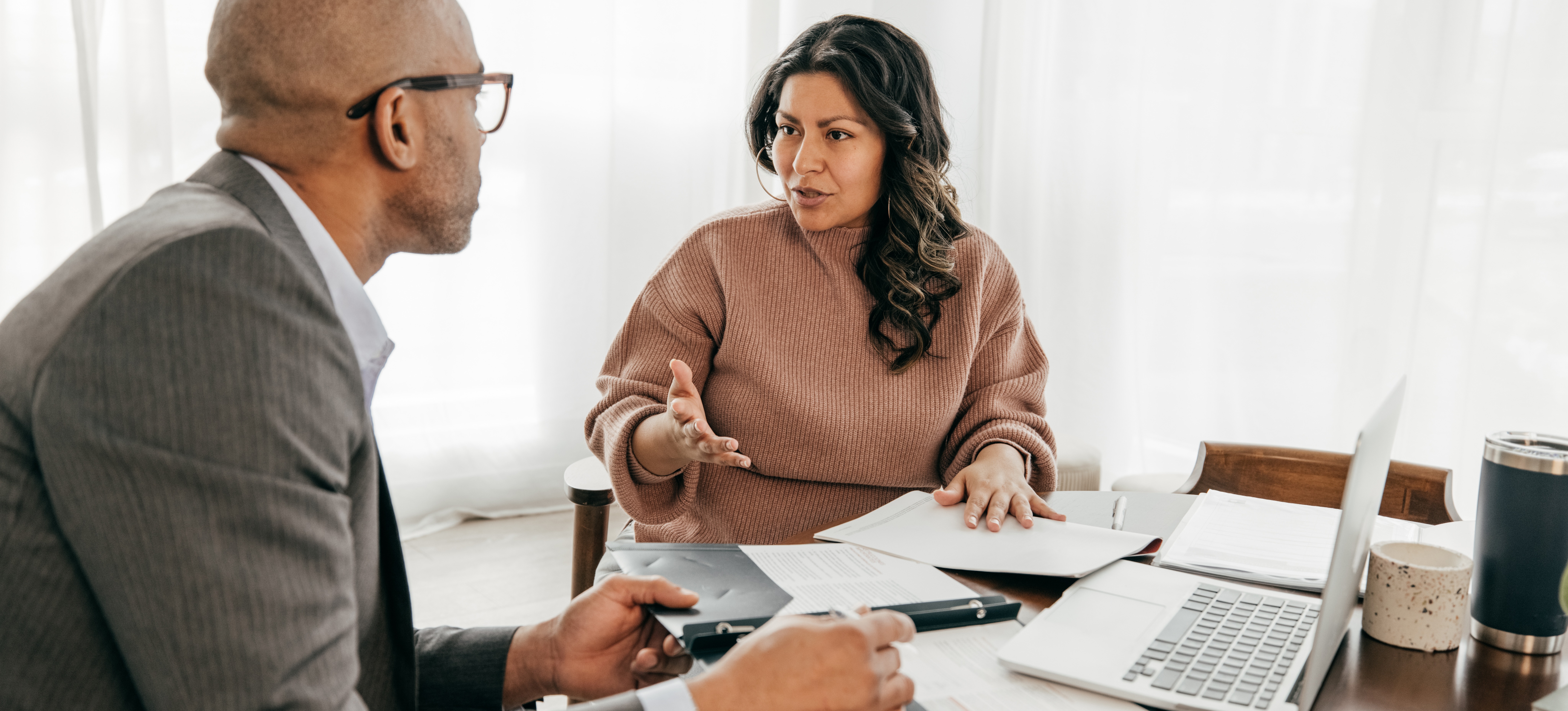 [Featured Image]: A professional with an accountancy degree meets with a client to review financial information.