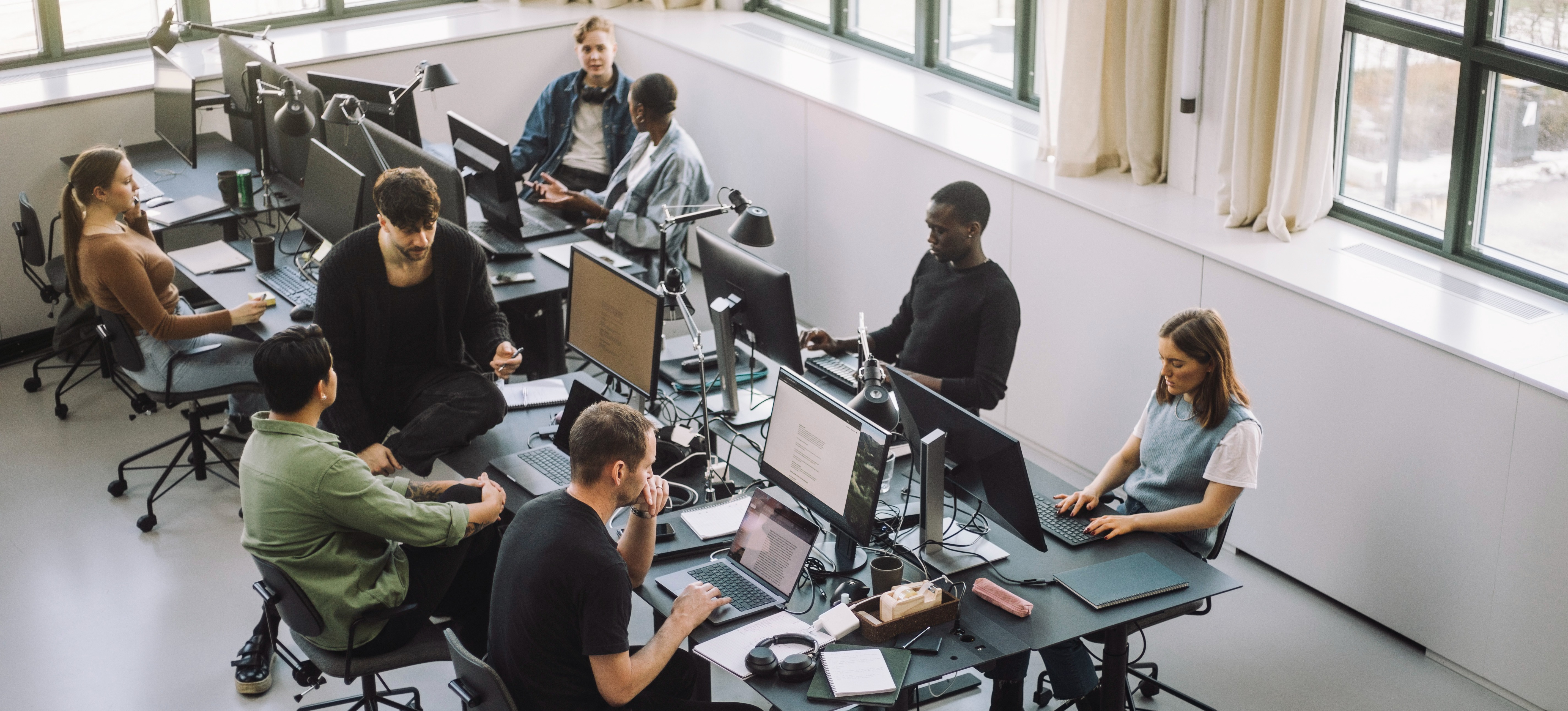 [Featured Image] Businessmen in an office workspace use computers to create smart shopping campaigns