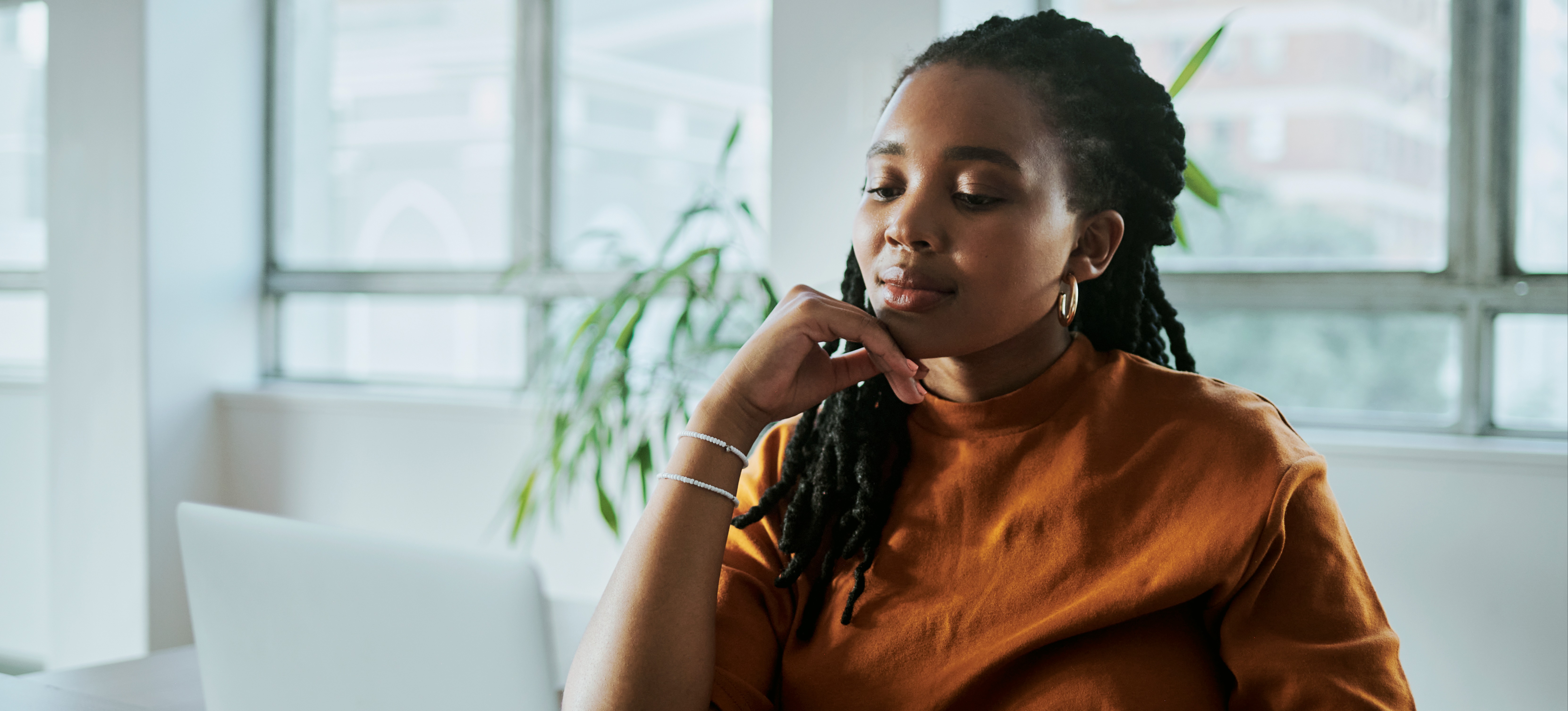 [Featured Image] A person sits at a desk and works on their laptop using generative AI to create content for their website.
