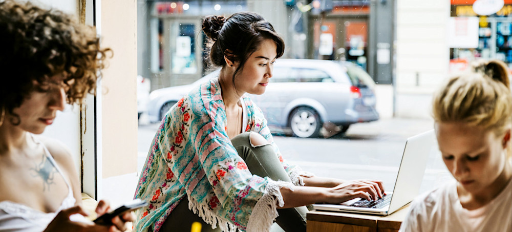 [Featured image]: A person sitting at a café searching for extracurricular activities on a laptop.