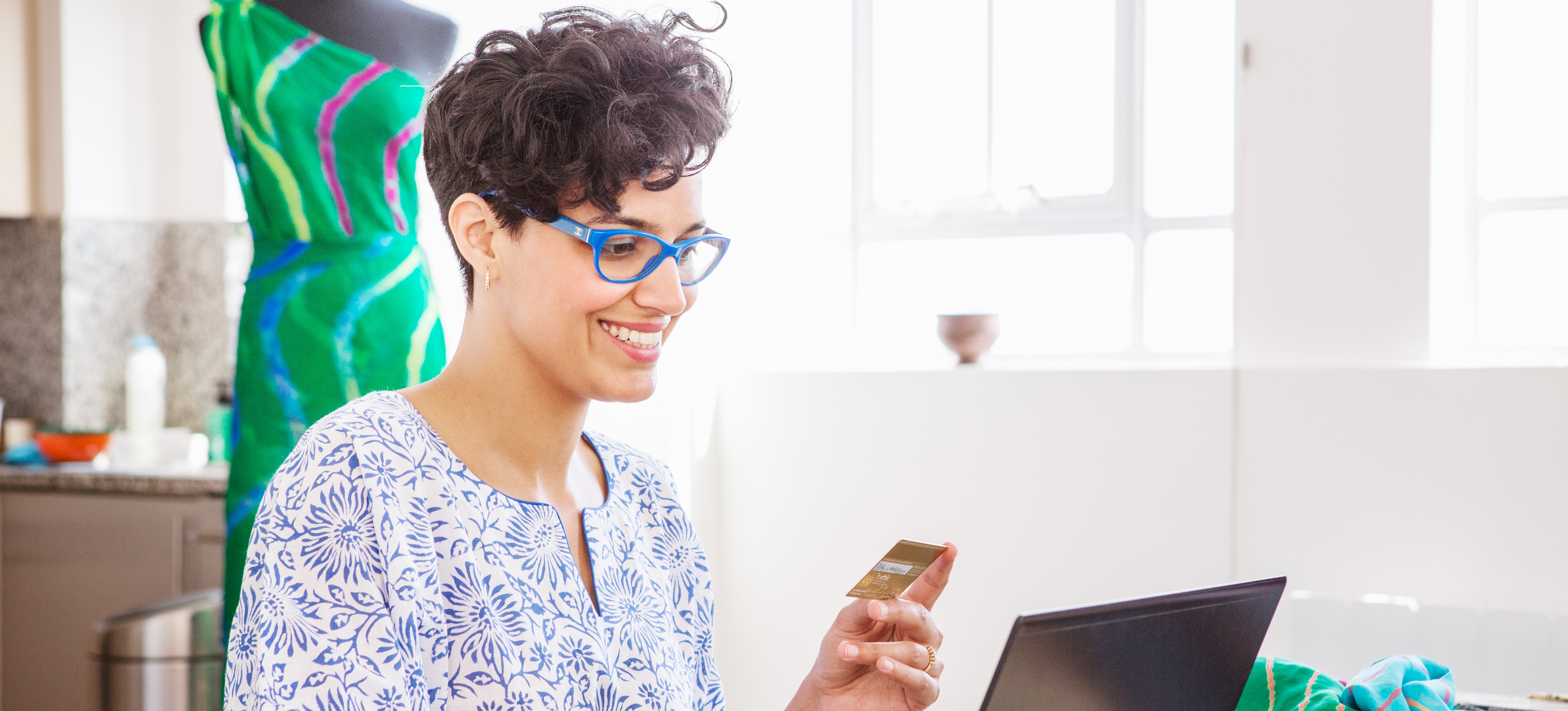 [Featured Image] A small business owner works to create an e-commerce website to increase sales and expand the brand’s reach.

