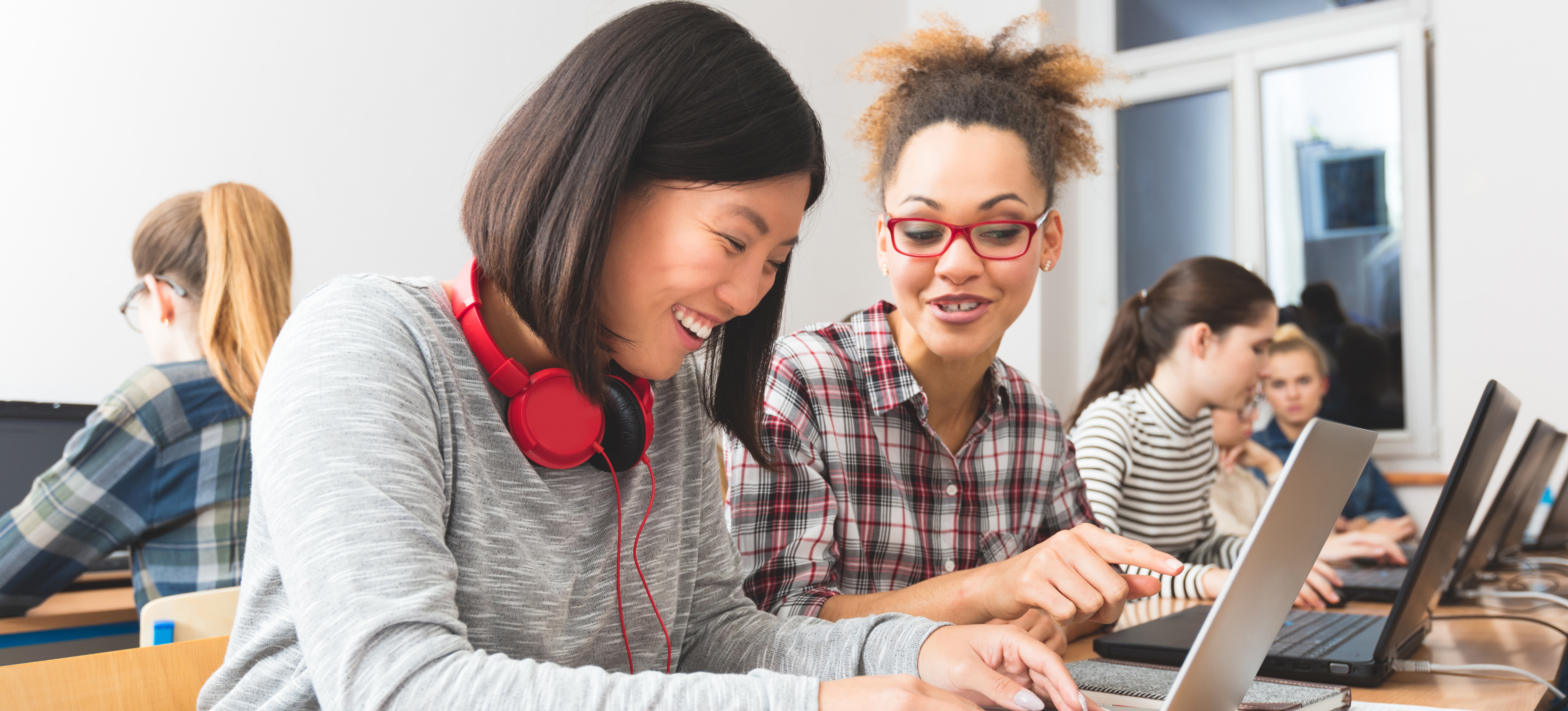 [Image en vedette] Deux femmes partagent leurs notes de cours.