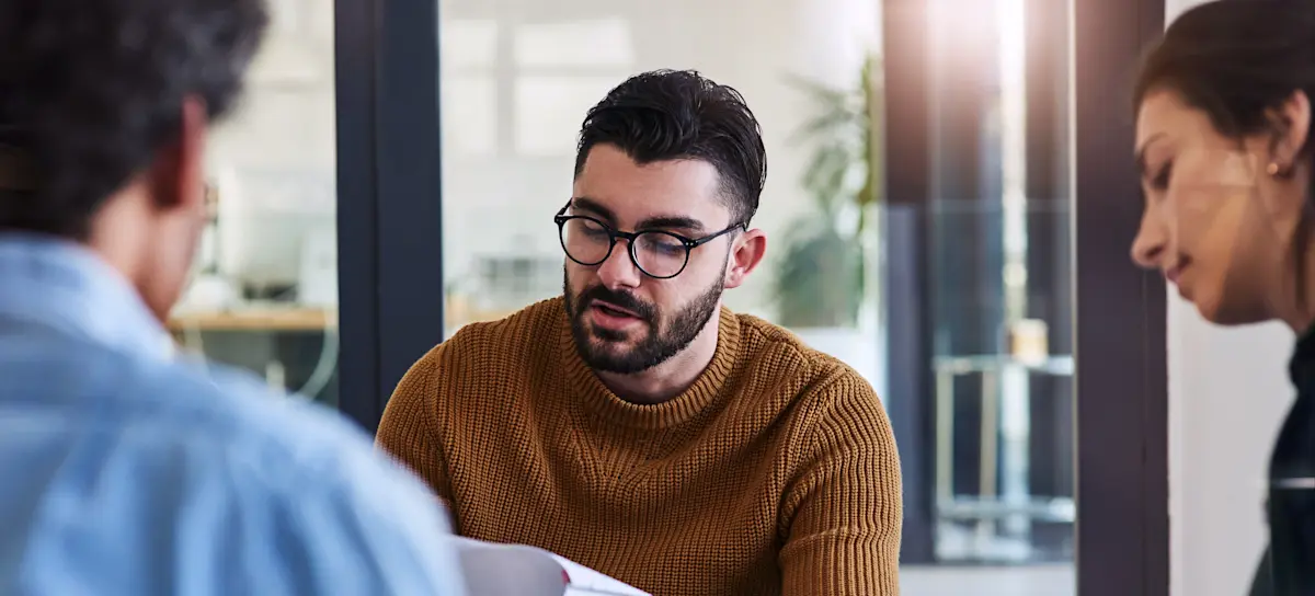 [Featured image] A person wearing a brown sweater and glasses is preparing for an interview as a product manager. 