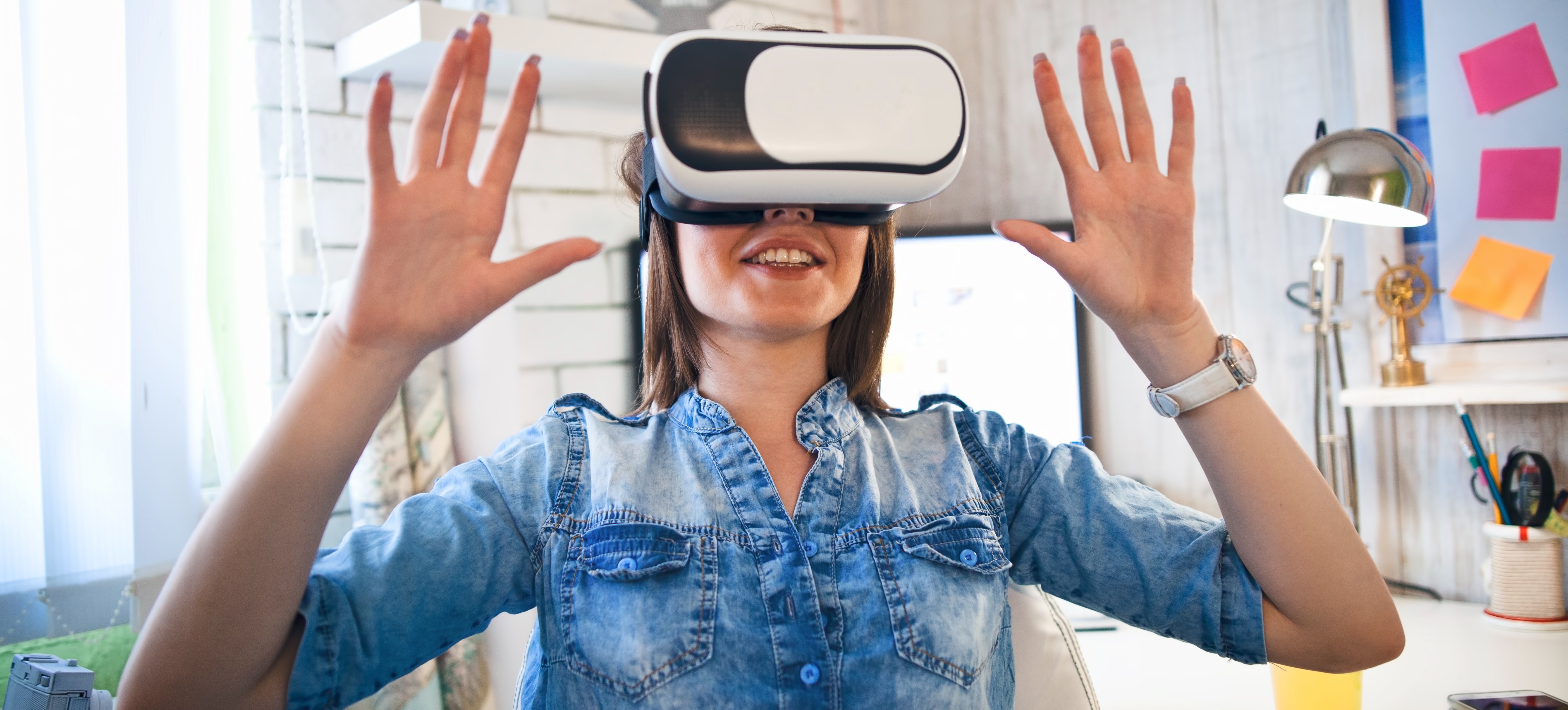 [Hauptbild] Eine Frau verwendet in ihrem Büro ein VR-Headset, um verschiedene Virtual-Reality-Beispiele zu erkunden.
