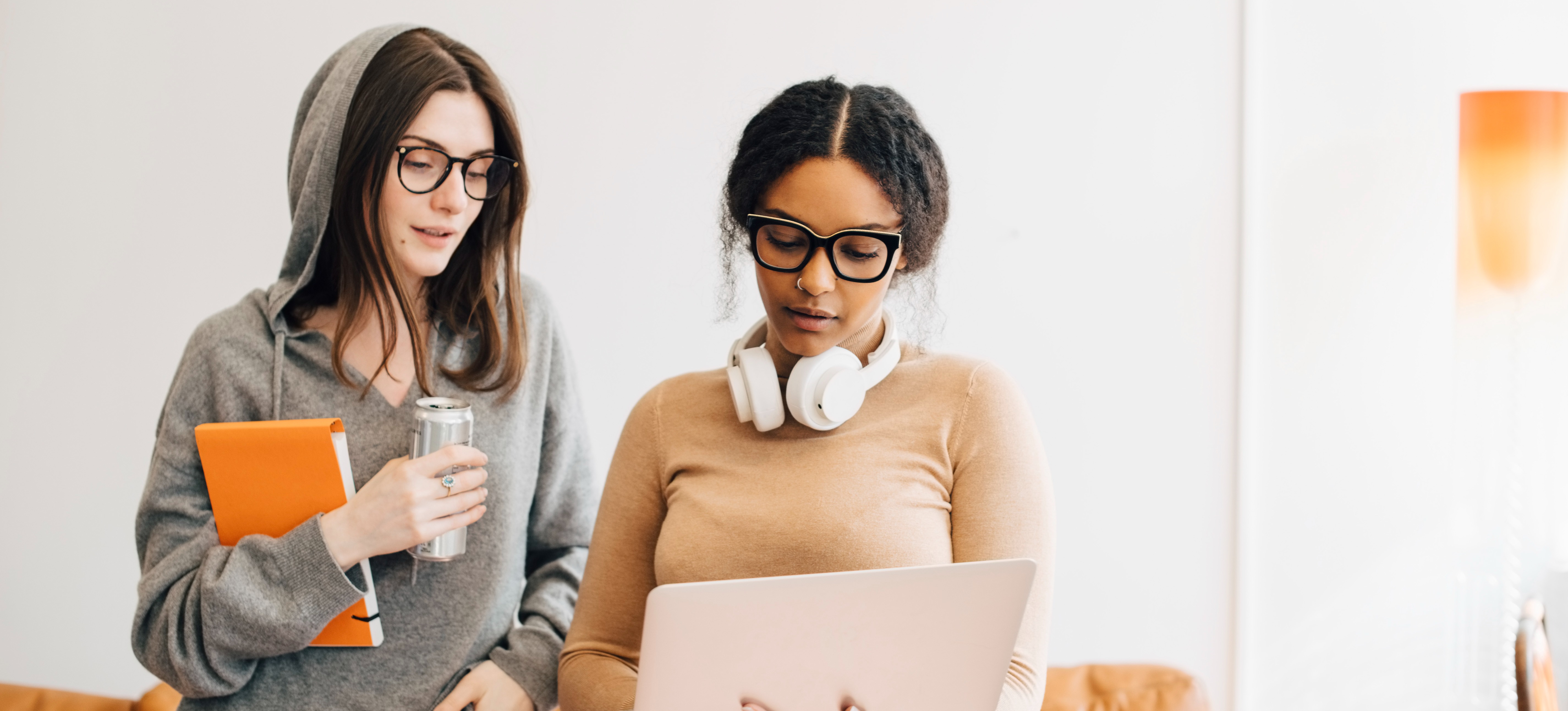 [Featured Image] Two learners compare notes about their coding bootcamps and the assignments they must complete. 
