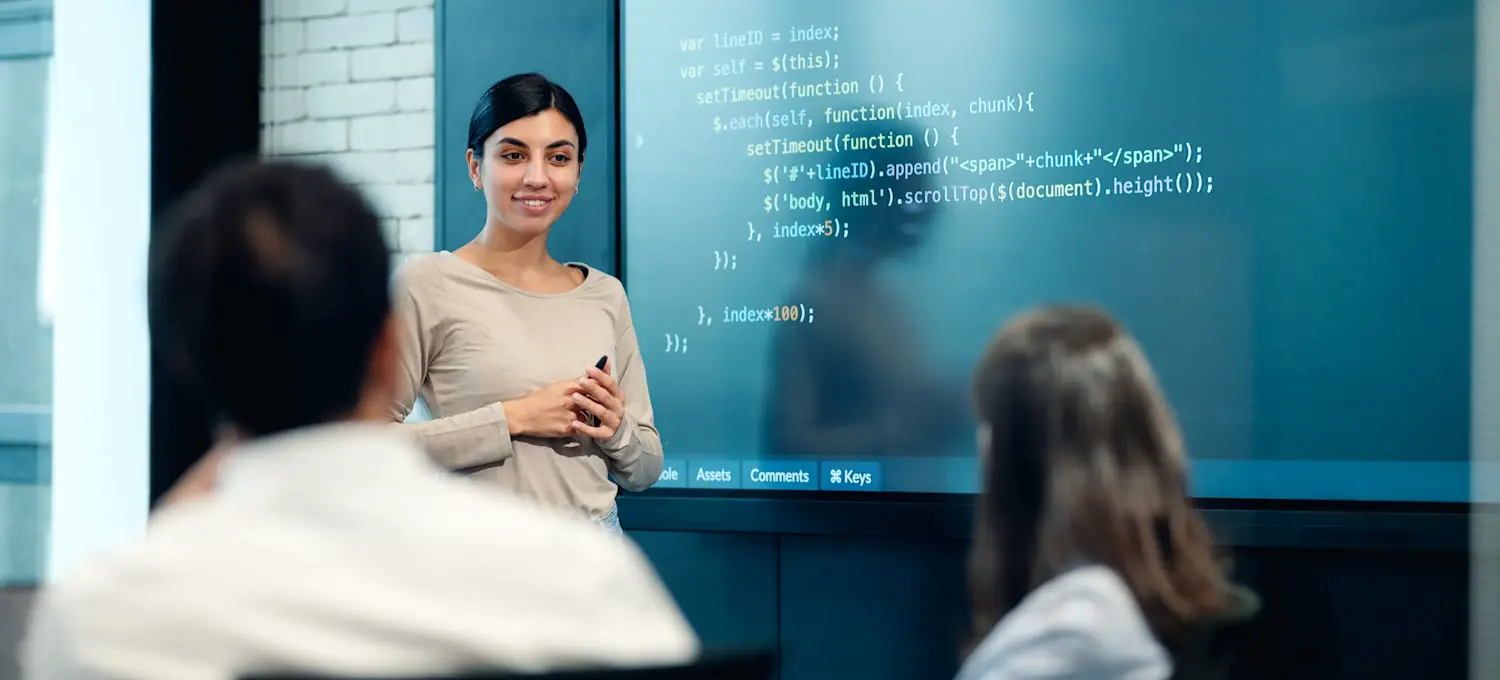 [Featured Image] An instructor teaching students in a learning environment, discussing techniques to improve programming skills.