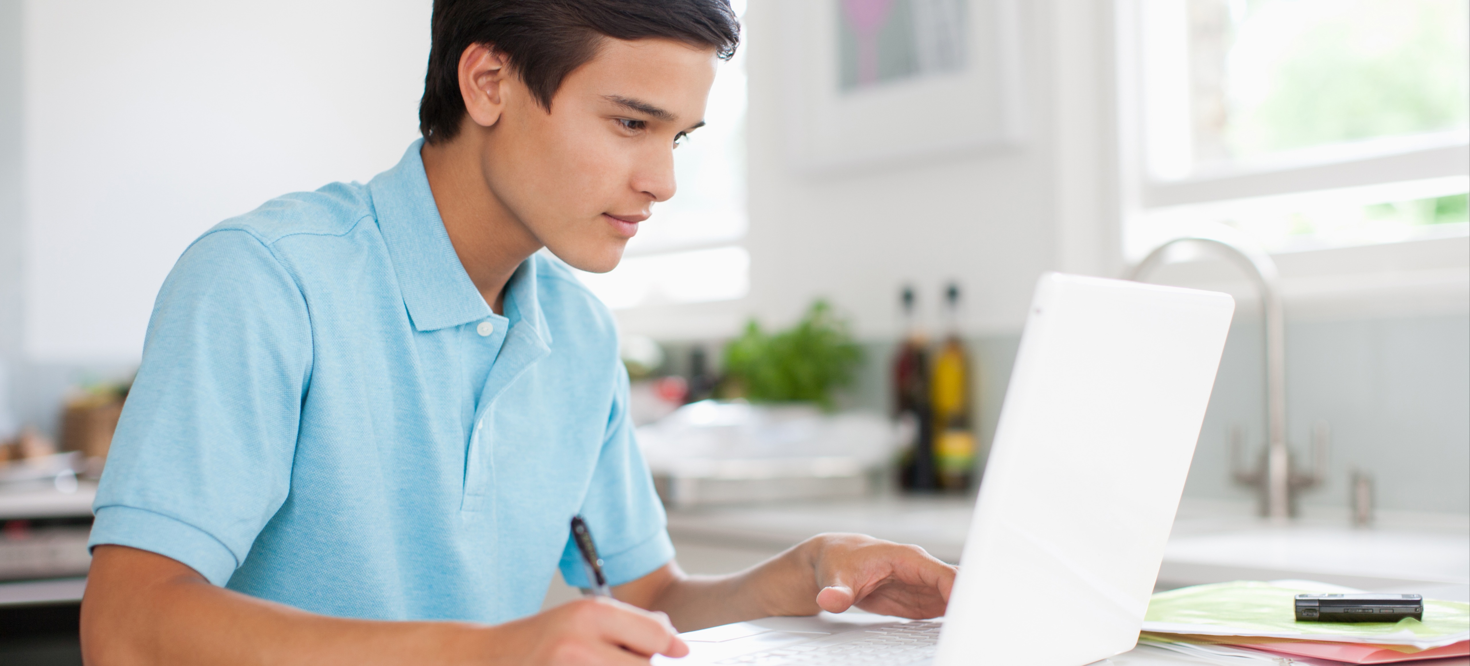 [Featured Image] A student searches on his laptop how many classes he should take in college. 
