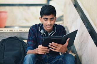 [Featured image] A learner is reading about encapsulation on their tablet while sitting on a flight of stairs. 