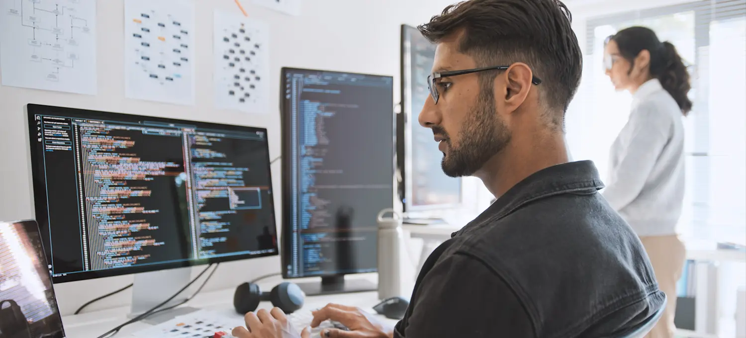 [Featured Image] A software developer who earned a Red Hat certification works on a project in a professional environment, focusing on coding and system development.
