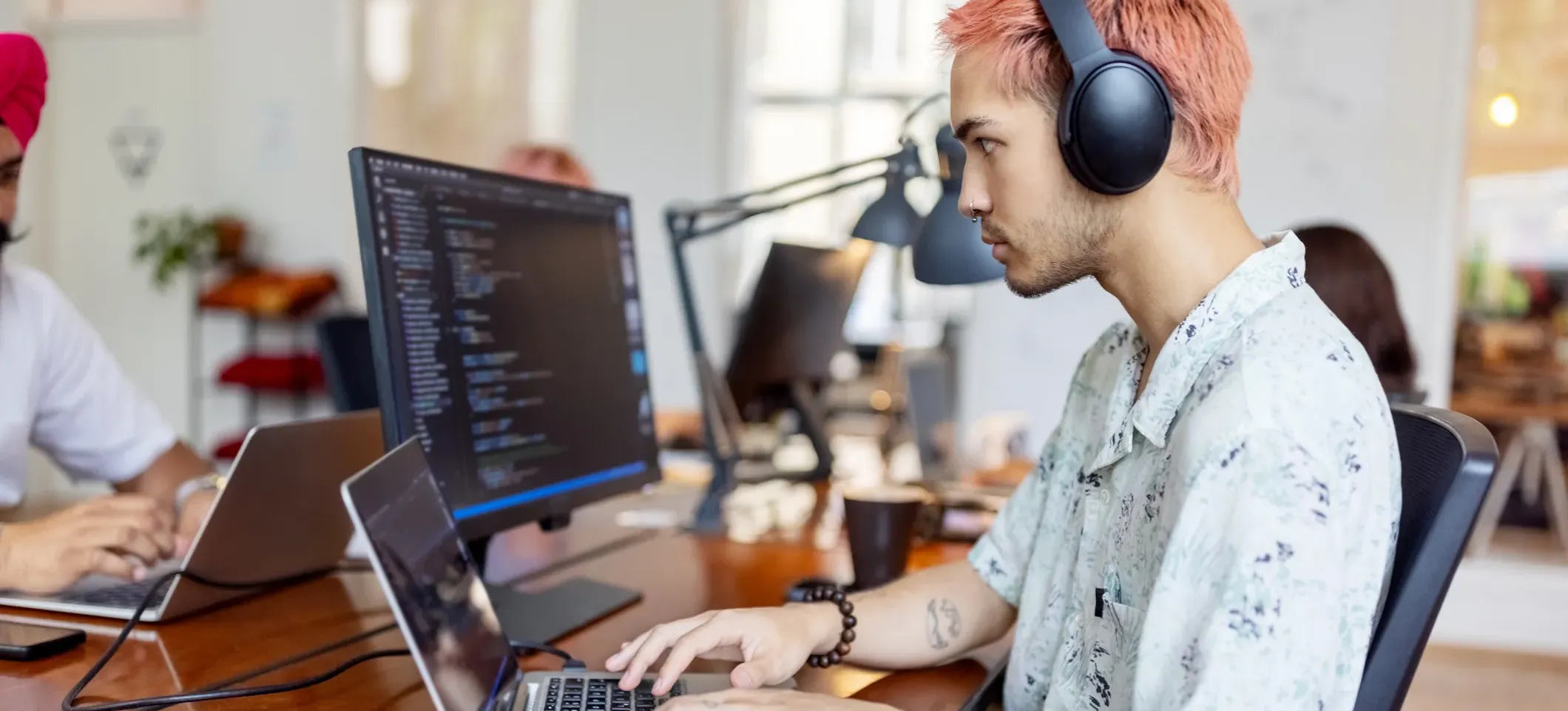 [Featured Image]: A man works on a laptop exploring string in C programming.
