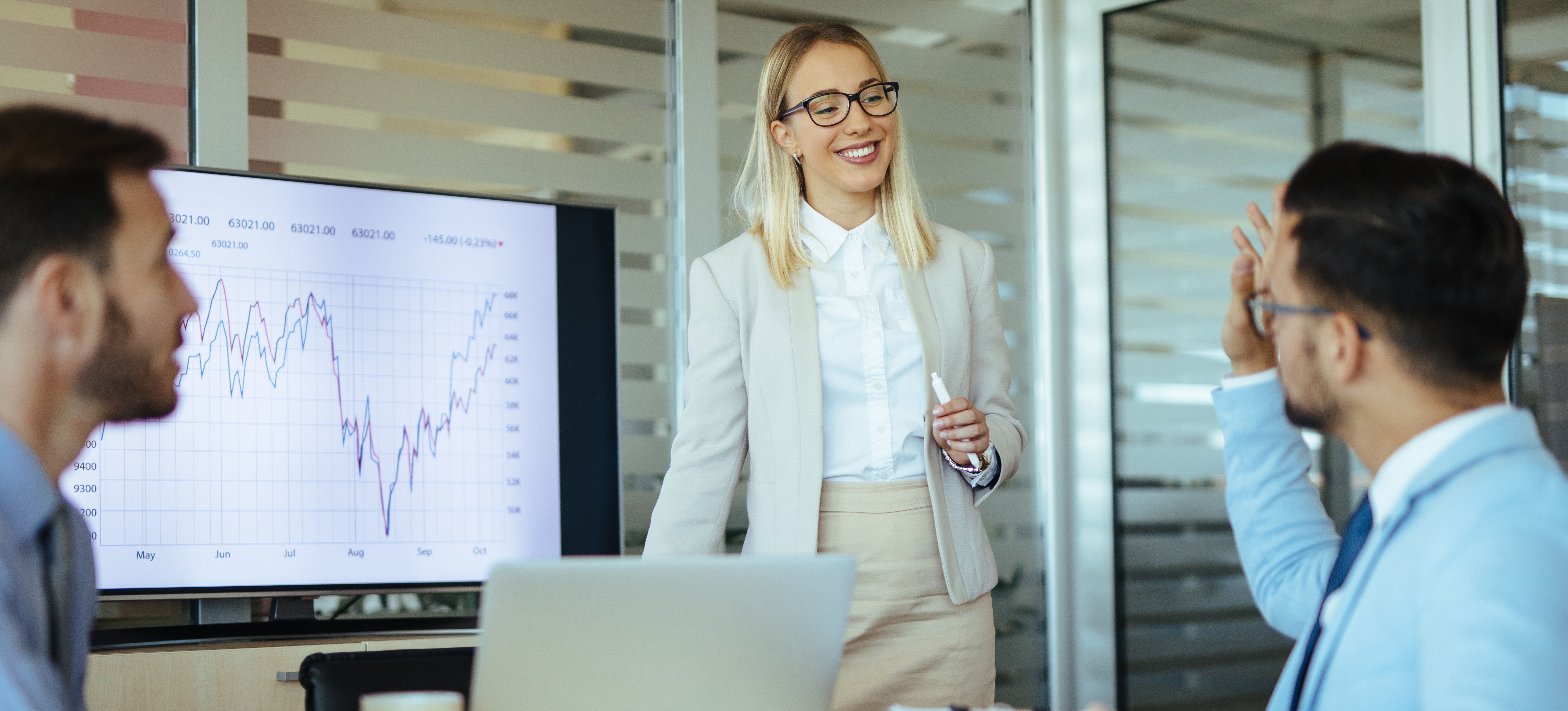 [Featured Image] In a meeting, a marketing coordinator gives a presentation to their colleagues. 