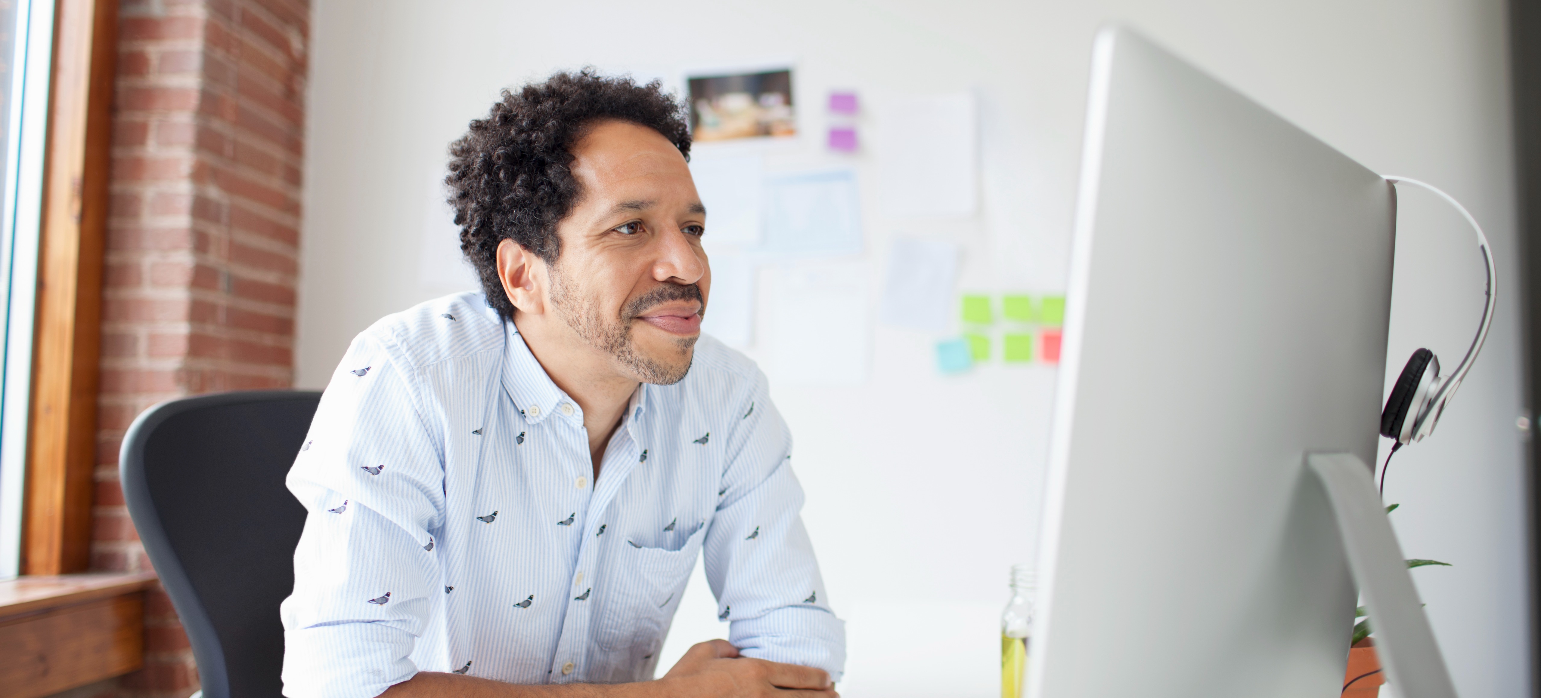 [Featured Image] A businessman sits in his office and reads about reinforcement learning from human feedback (RHF) and its role in various AI programs.
