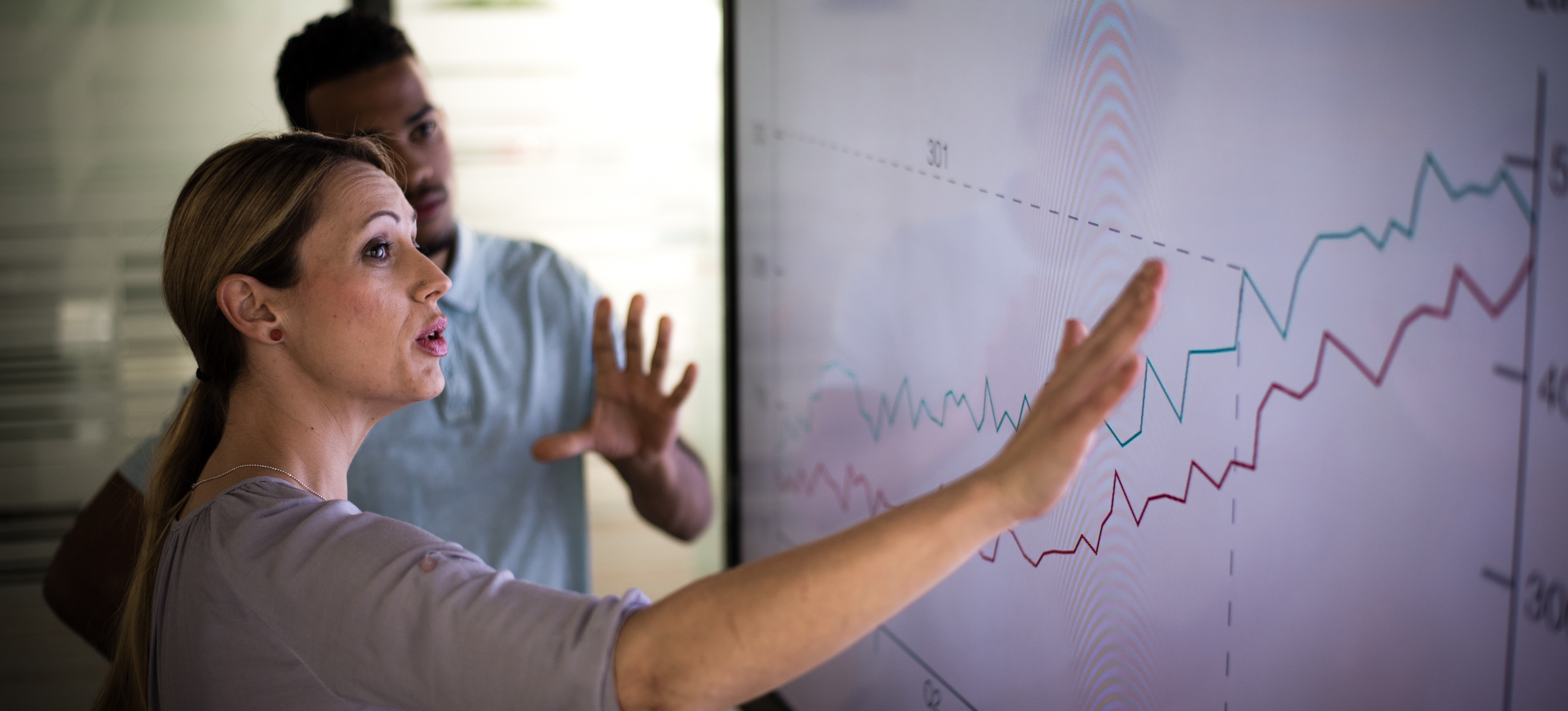 [Featured text] A woman and man review data looking for evidence of correlation vs causation.
