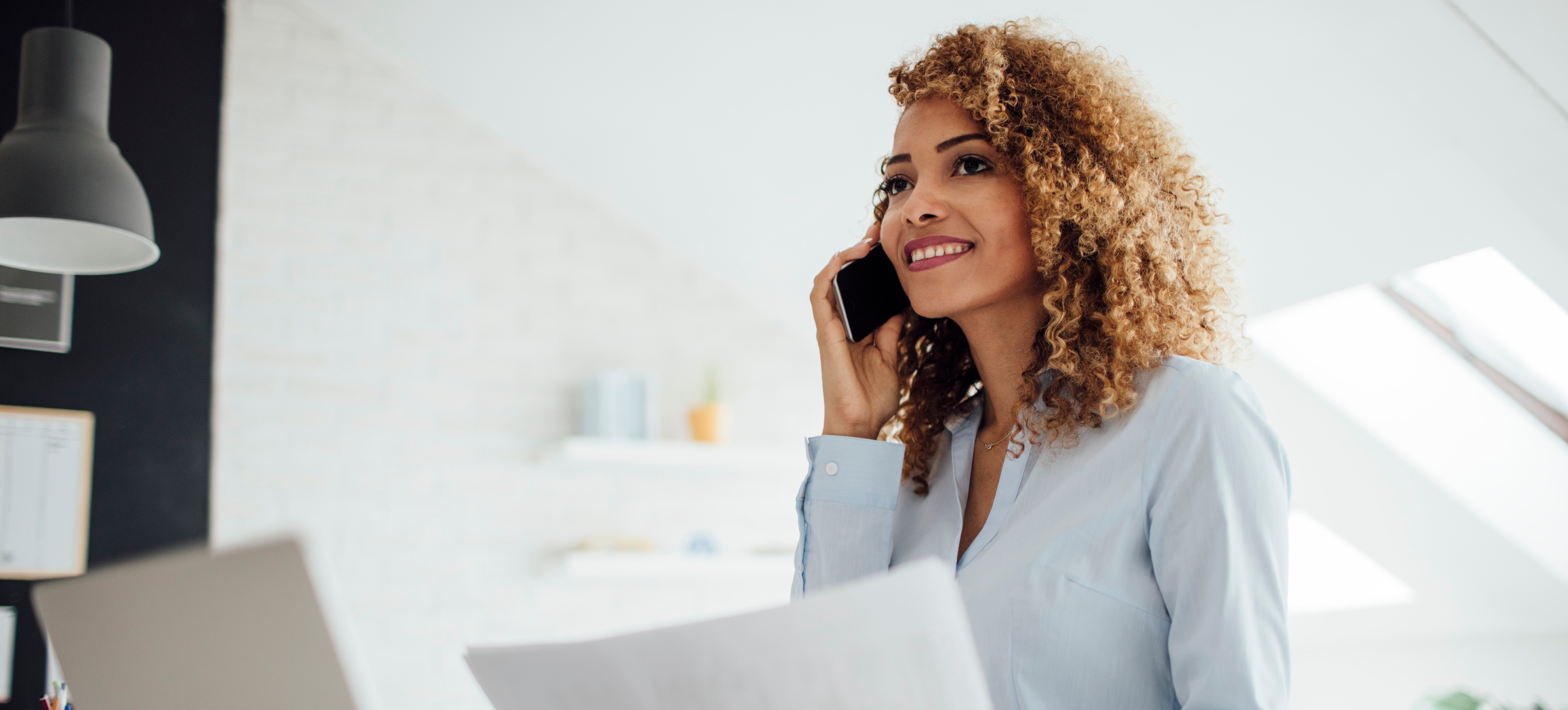 [Featured Image] A big data architect sits in their office and talks on the phone to a colleague about big data architecture.  