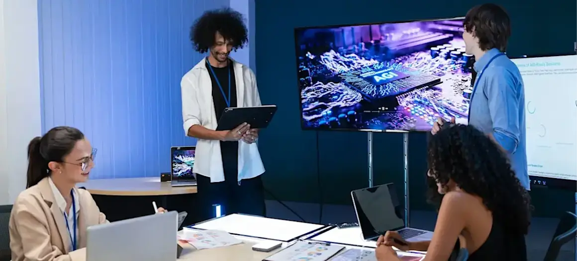 [Featured Image] A group of developers gathers in a workroom and discusses the capabilities of artificial general intelligence.