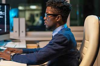 [Featured image] An IT professional sits at a computer workstation and writes a script to automate a task.