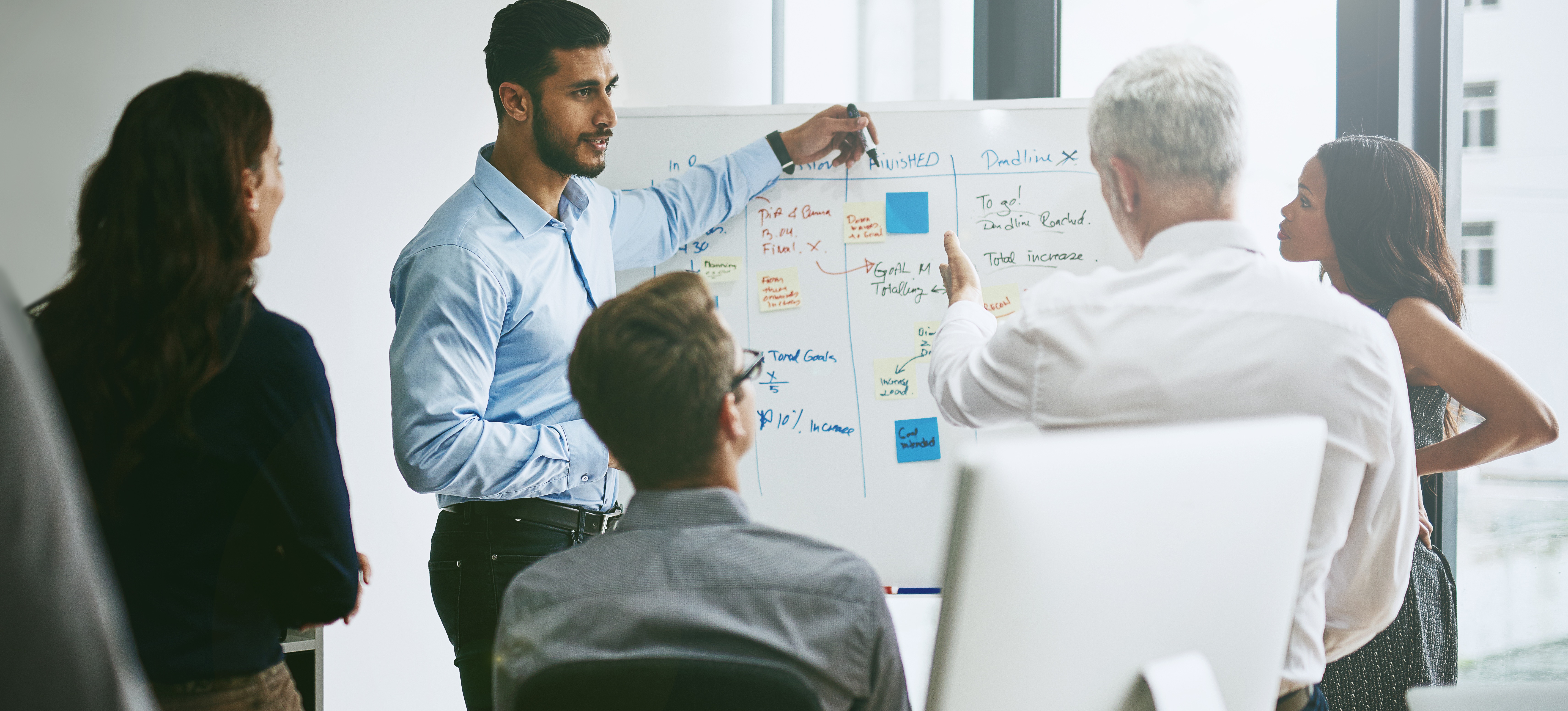 [Hauptbild] Eine Gruppe von Kollegen trifft sich in einem Konferenzraum, um Prozessmanagementstrategien zu besprechen.