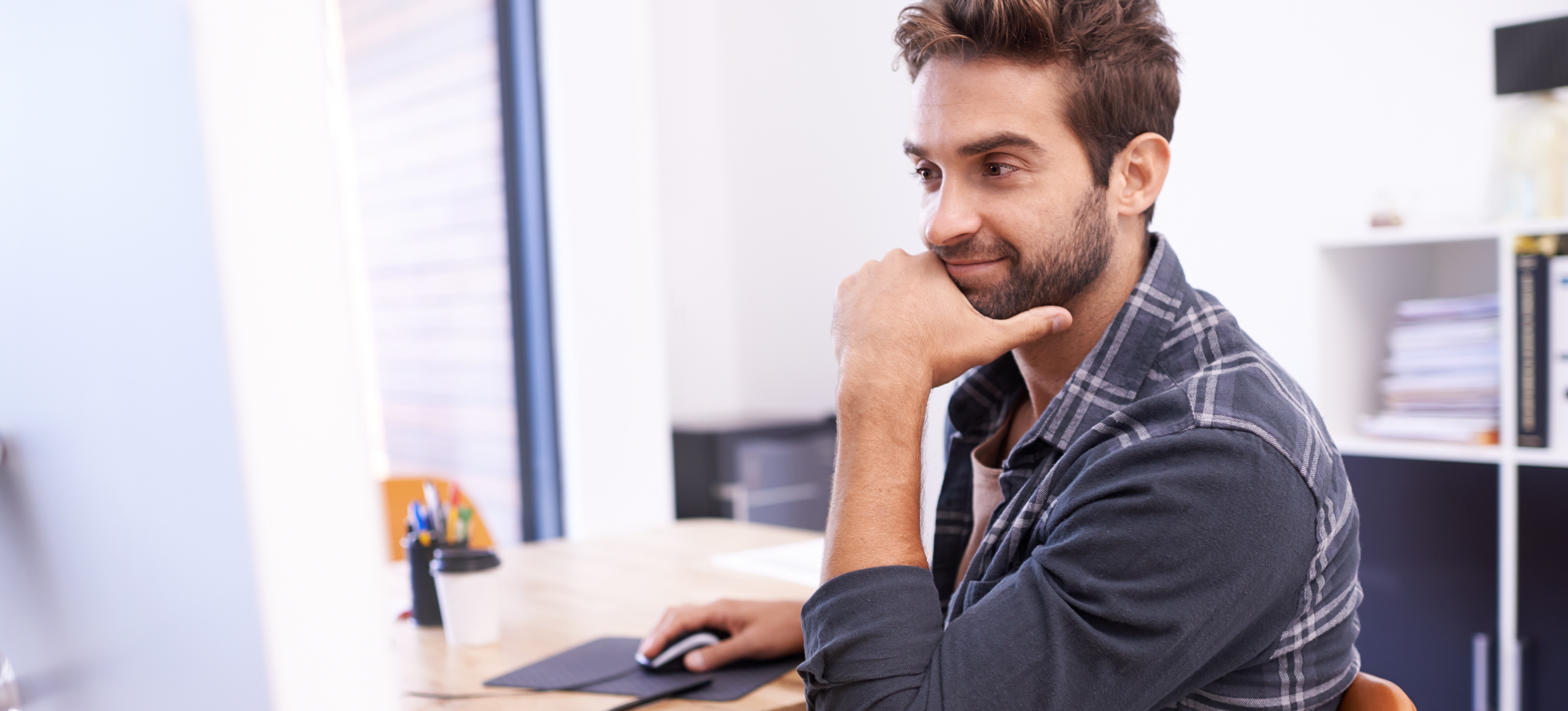 [Featured Image] A data scientist dressed in business casual attire sits at their home office and studies statistical learning vs. machine learning on their computer.
