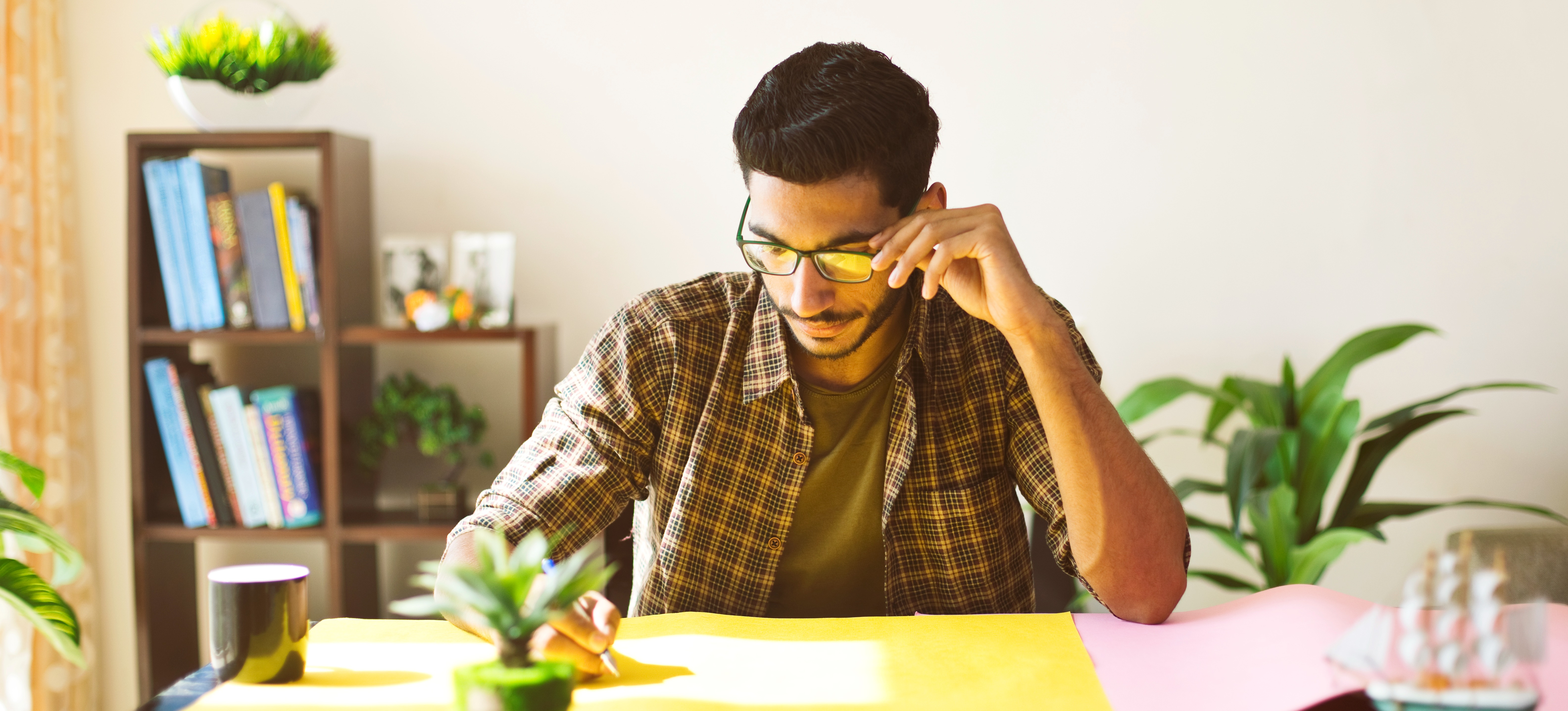[Featured Image] A graphic artist sits at a desk, working on a design project.

