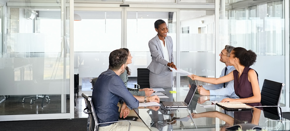 [Feature Image] An IT manager working in one of the highest-paying IT jobs meets with the IT team to discuss the ongoing strategy for the company’s digital transformation.
