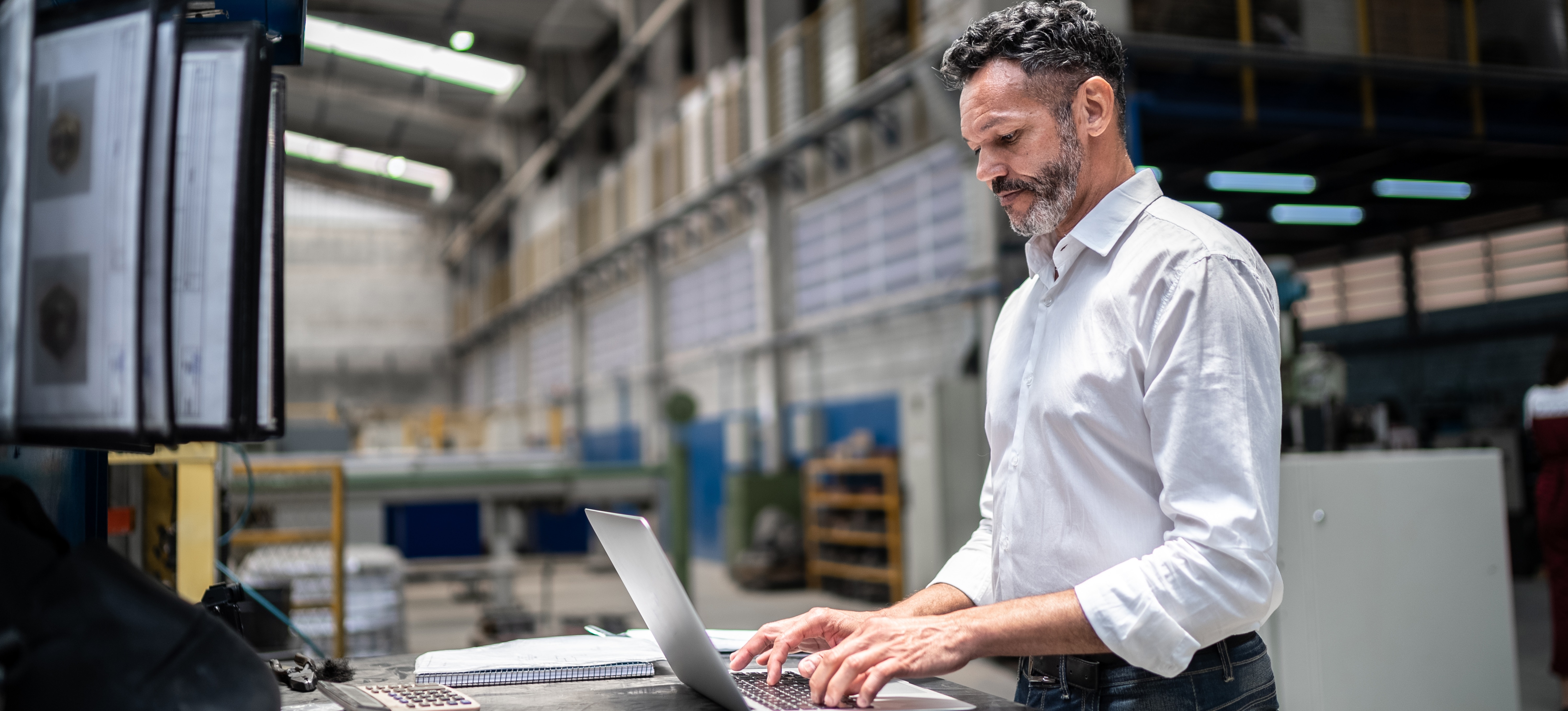 [Featured Image] A senior logistics analyst earning an above-average logistics analyst salary works in a professional environment to review supply chain data on a computer.
