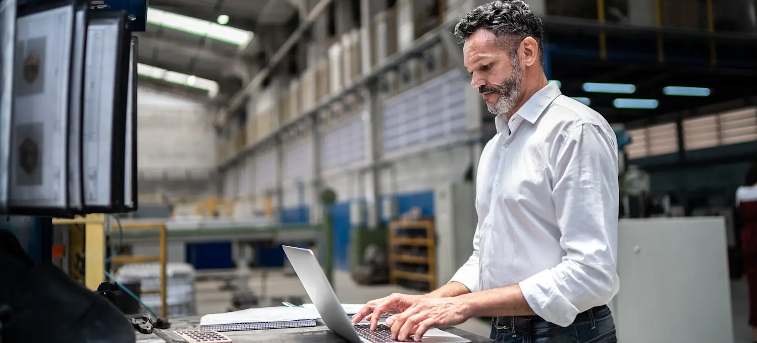 [Featured Image] A senior logistics analyst earning an above-average logistics analyst salary works in a professional environment to review supply chain data on a computer.
