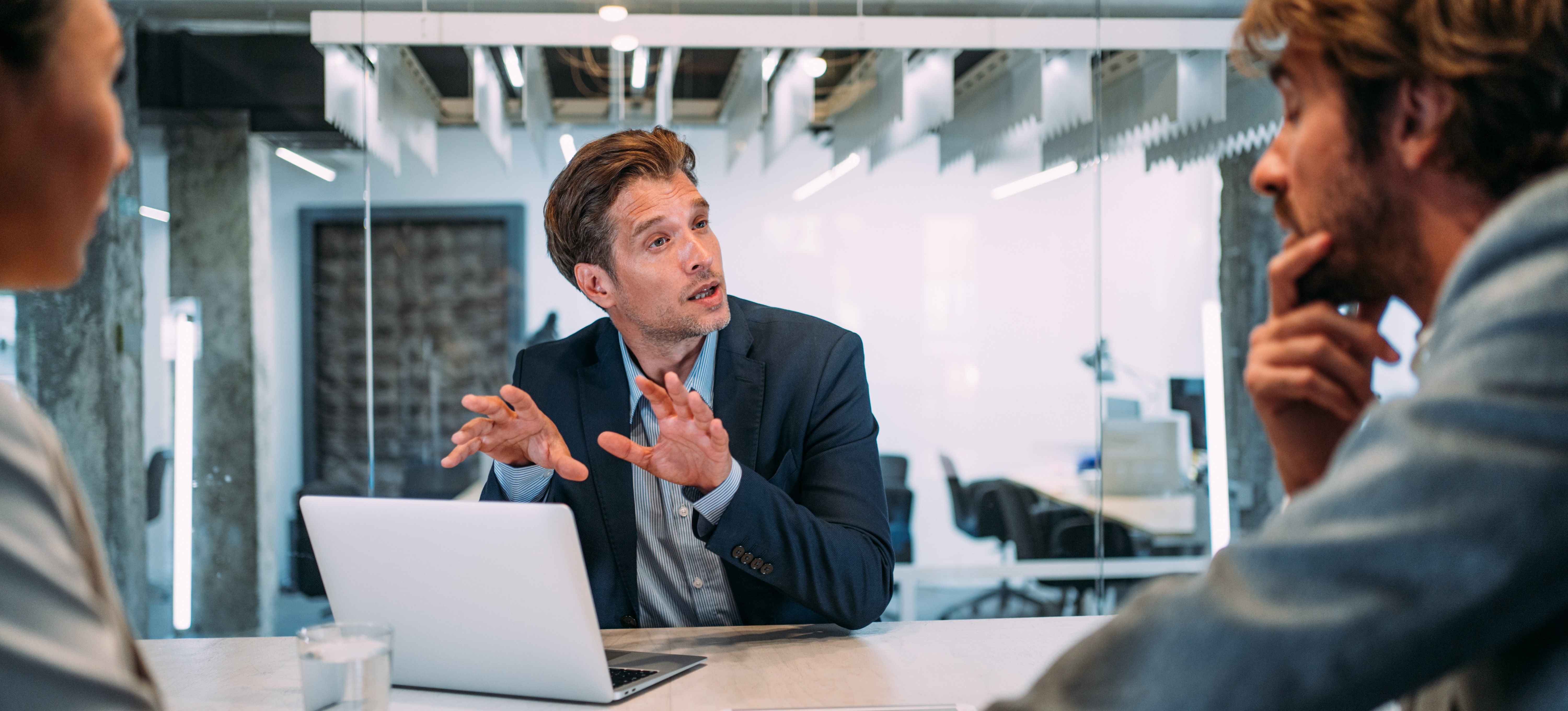 [Feature Image] A staff accountant meets with company leadership to discuss quarterly financial statements.
