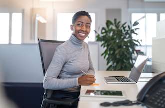 [Featured Image] A medical receptionist works at an office desk.