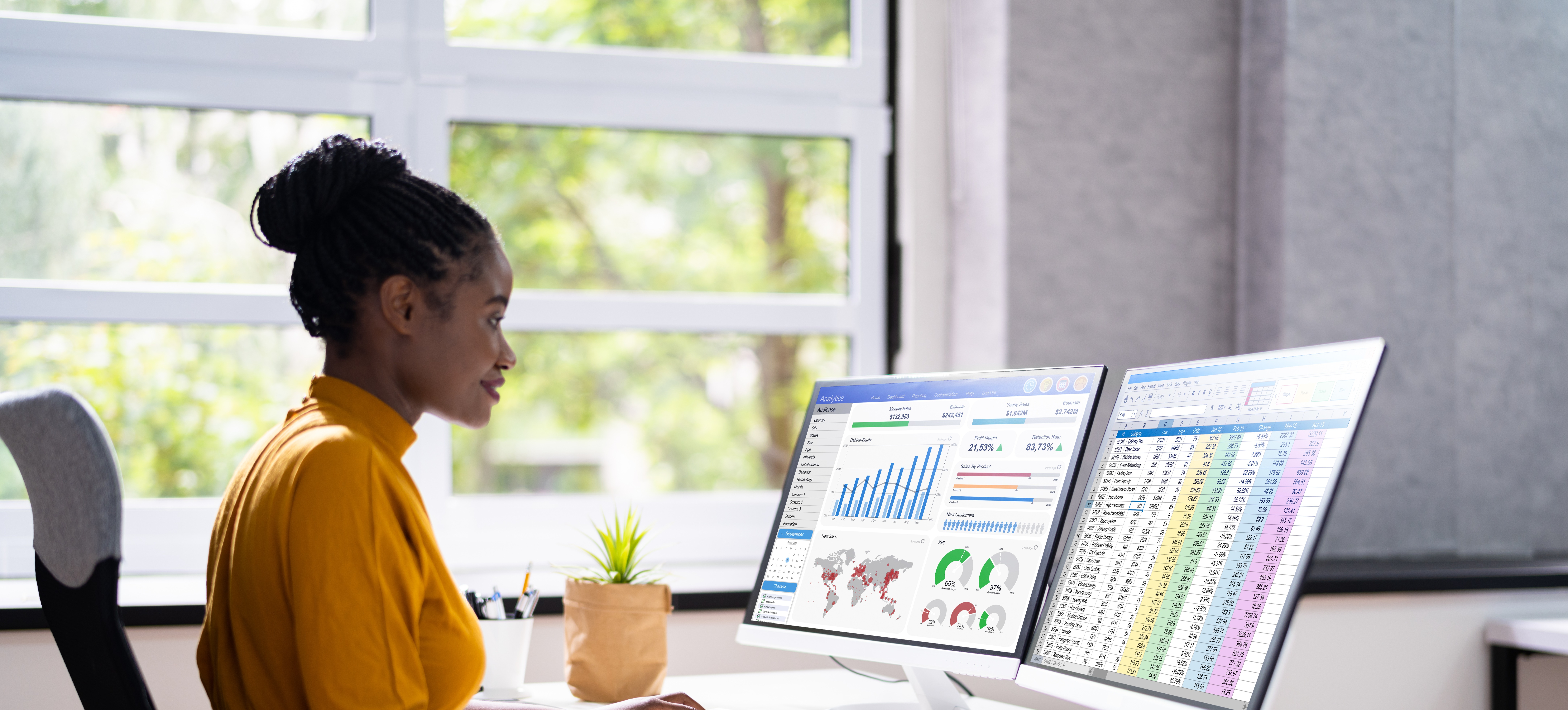 [Hauptbild] Eine Frau in einem gelben Kleid untersucht und analysiert Daten mithilfe von zwei Bildschirmen ihres Computers.