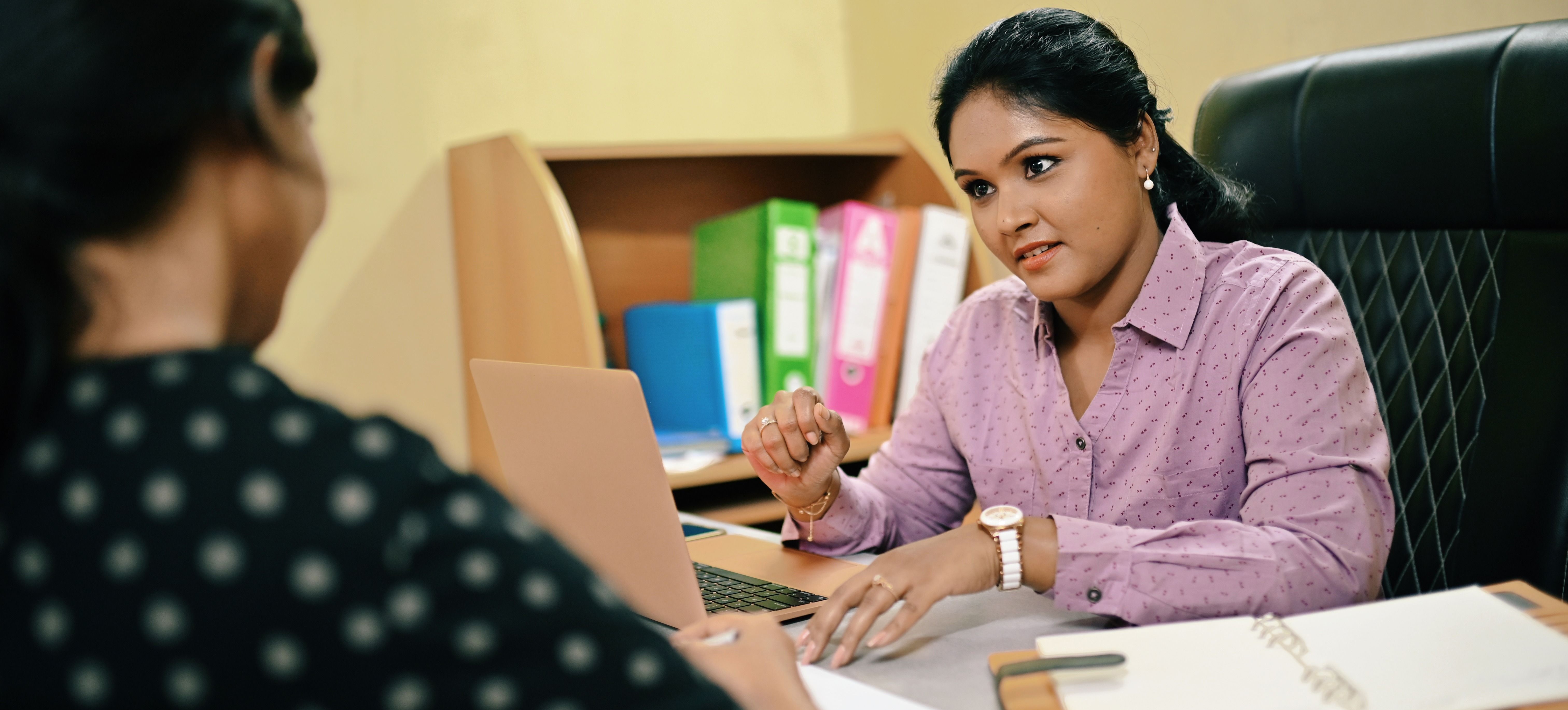 [Featured Image]: A professional applies her knowledge of how to answer STAR interview questions as she speaks with a hiring manager.
